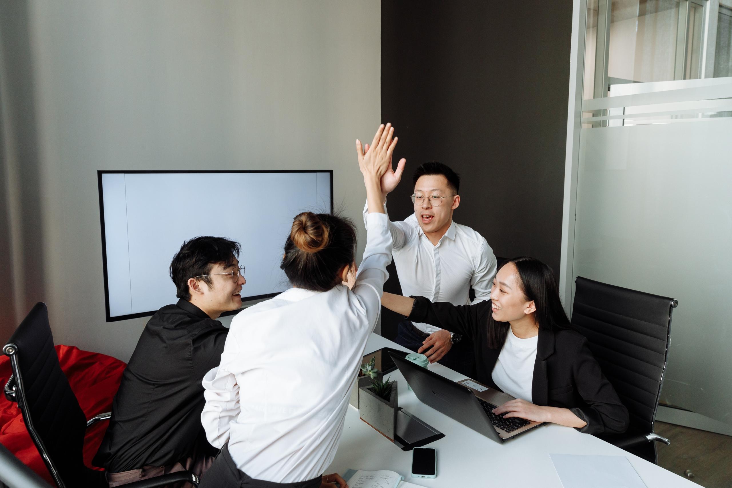 A team of translators high-5 each other.