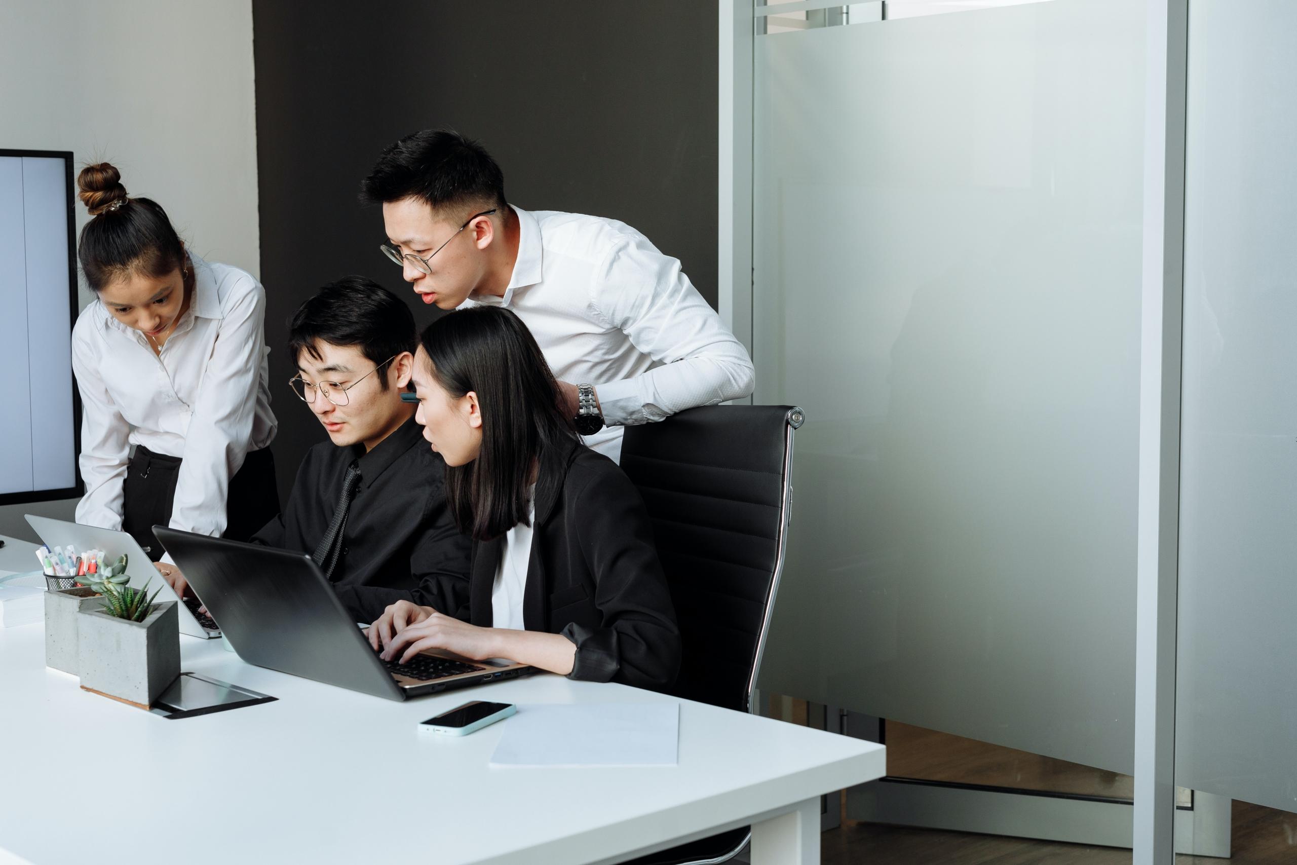 A group of Asian professionals work together.