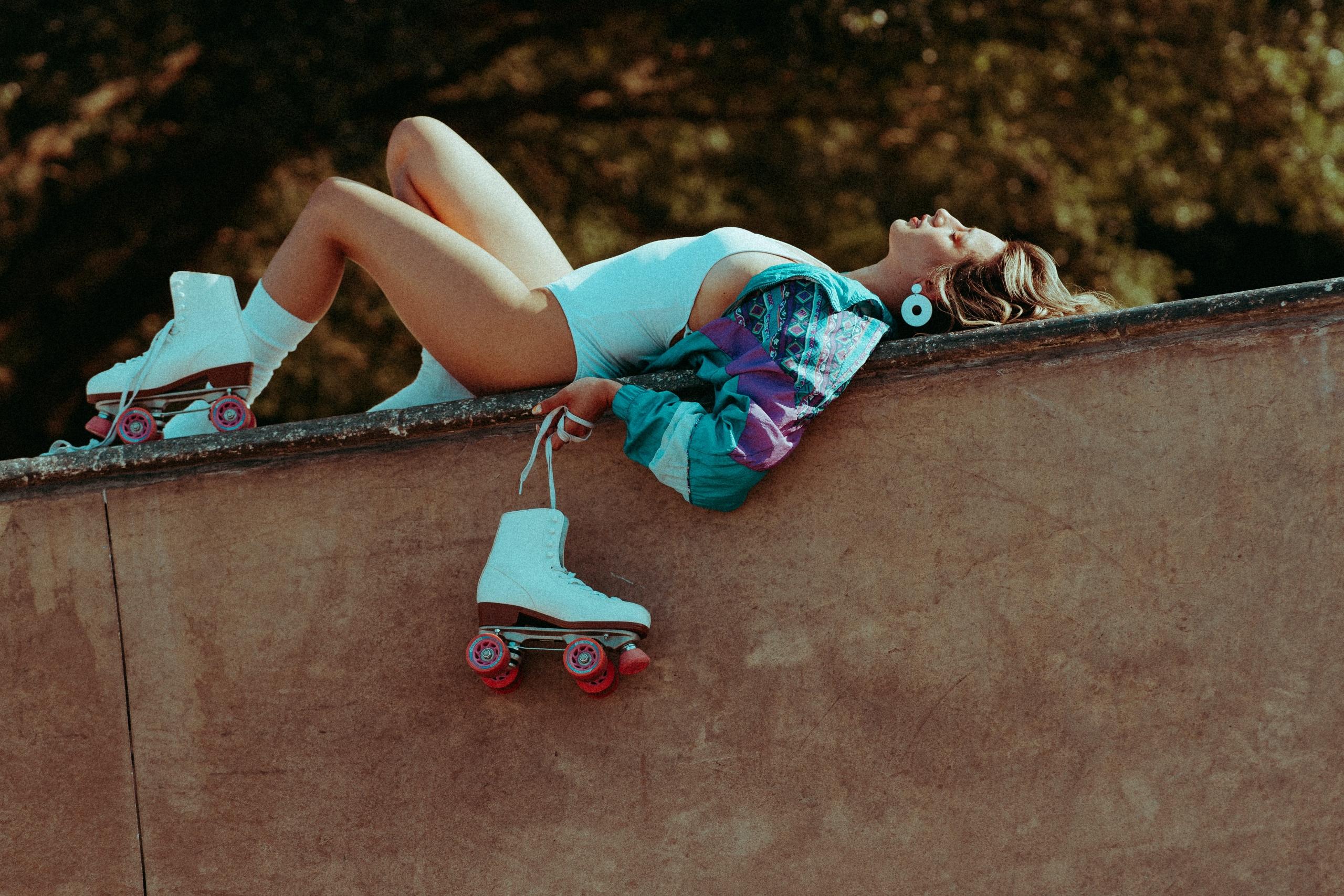 a woman reclines with skates on a ledge