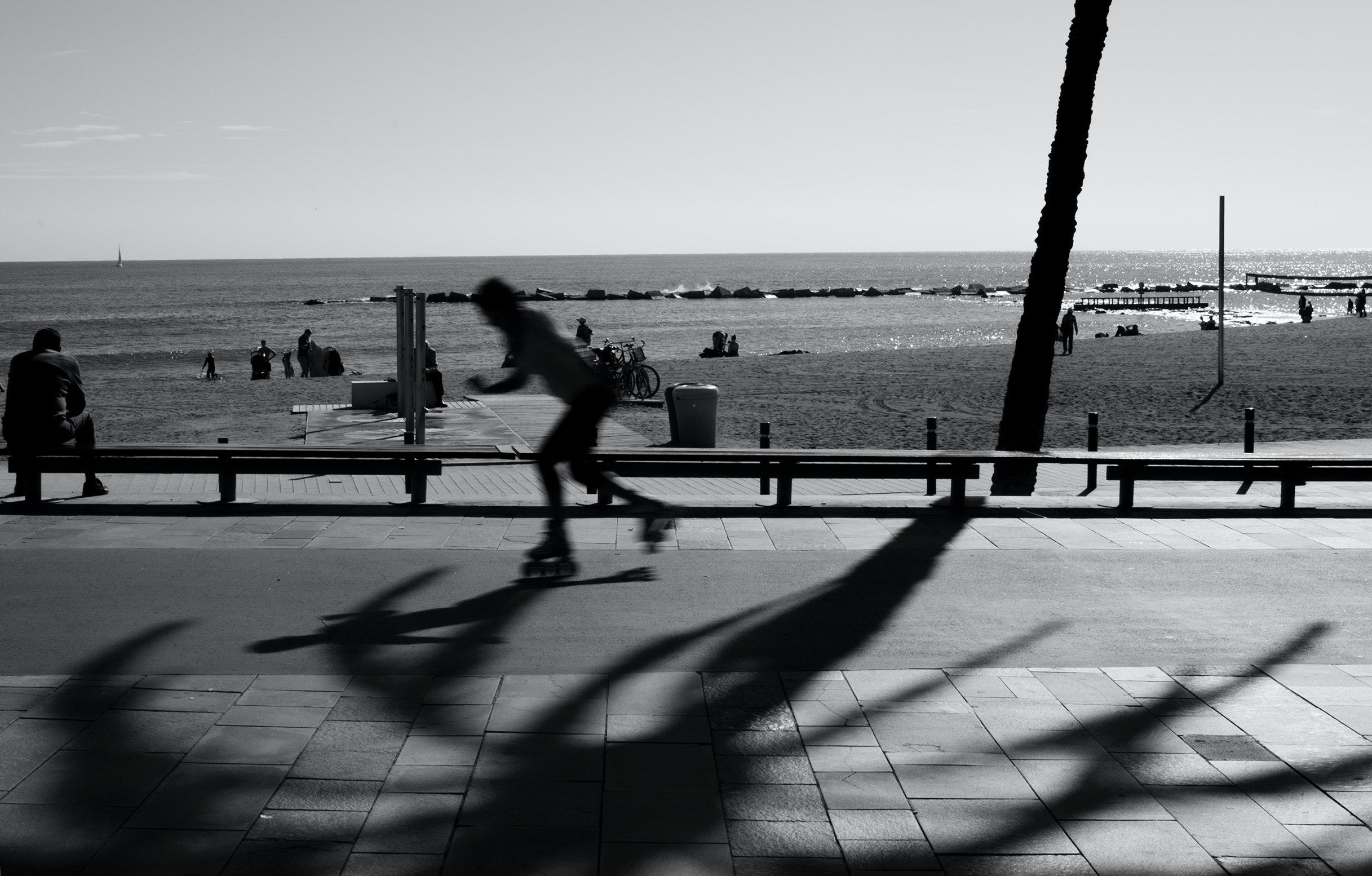 A skater moves quickly on a seaside road.