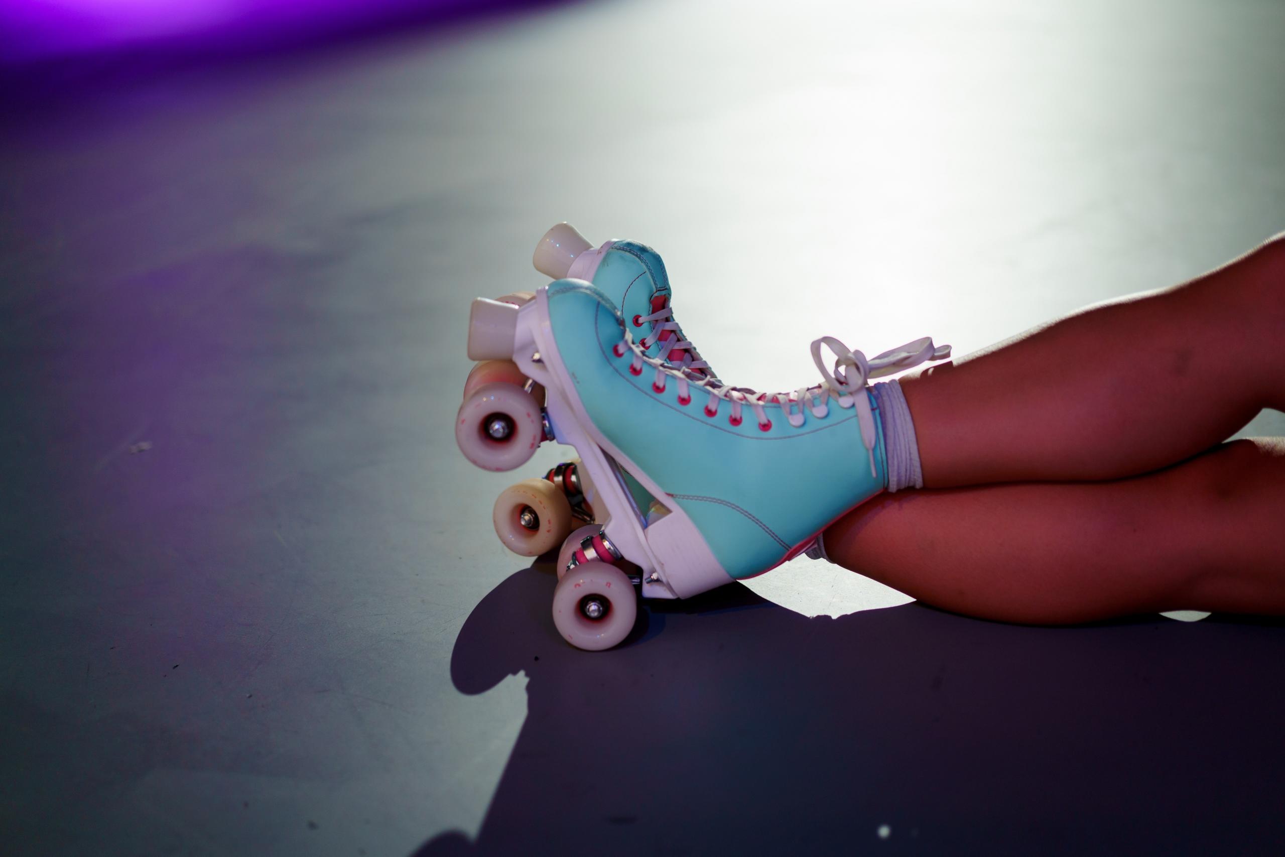 a person wears blue and pink roller skates.