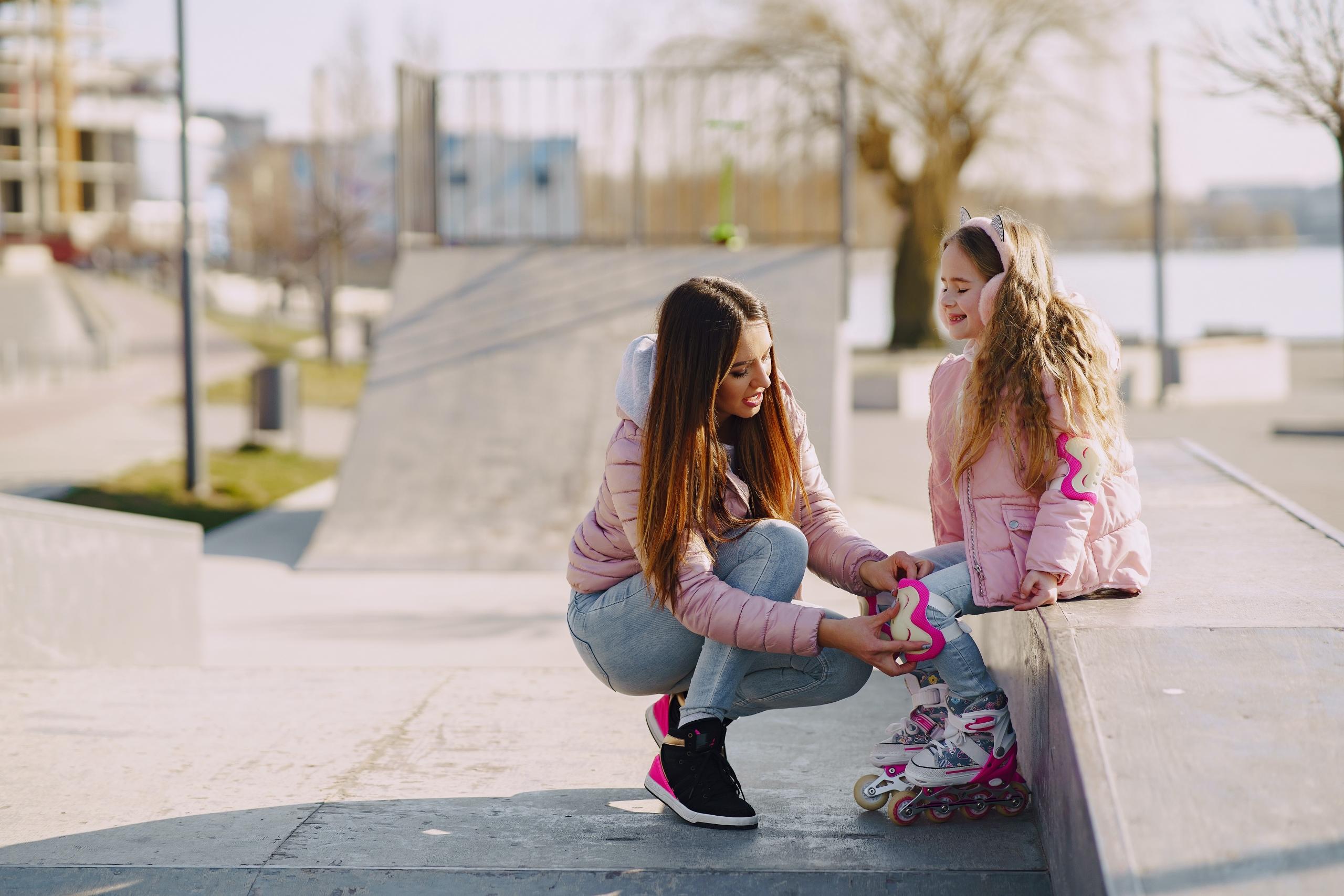 an adult helps a child with skates