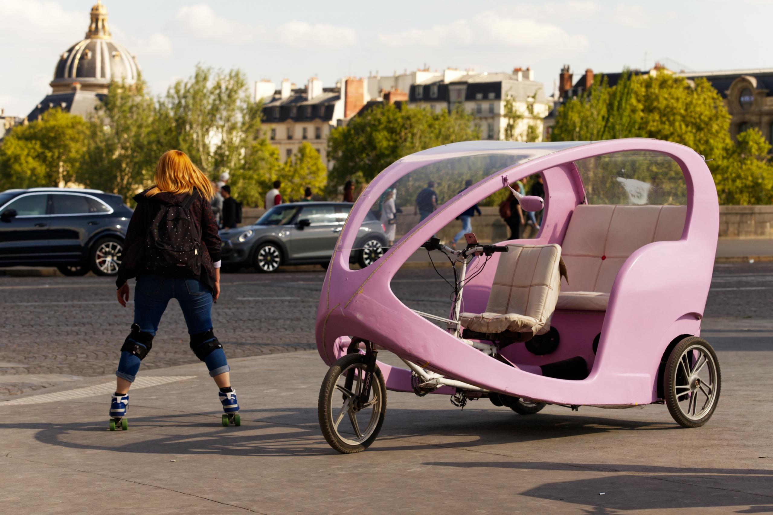 a woman skates near a unique car