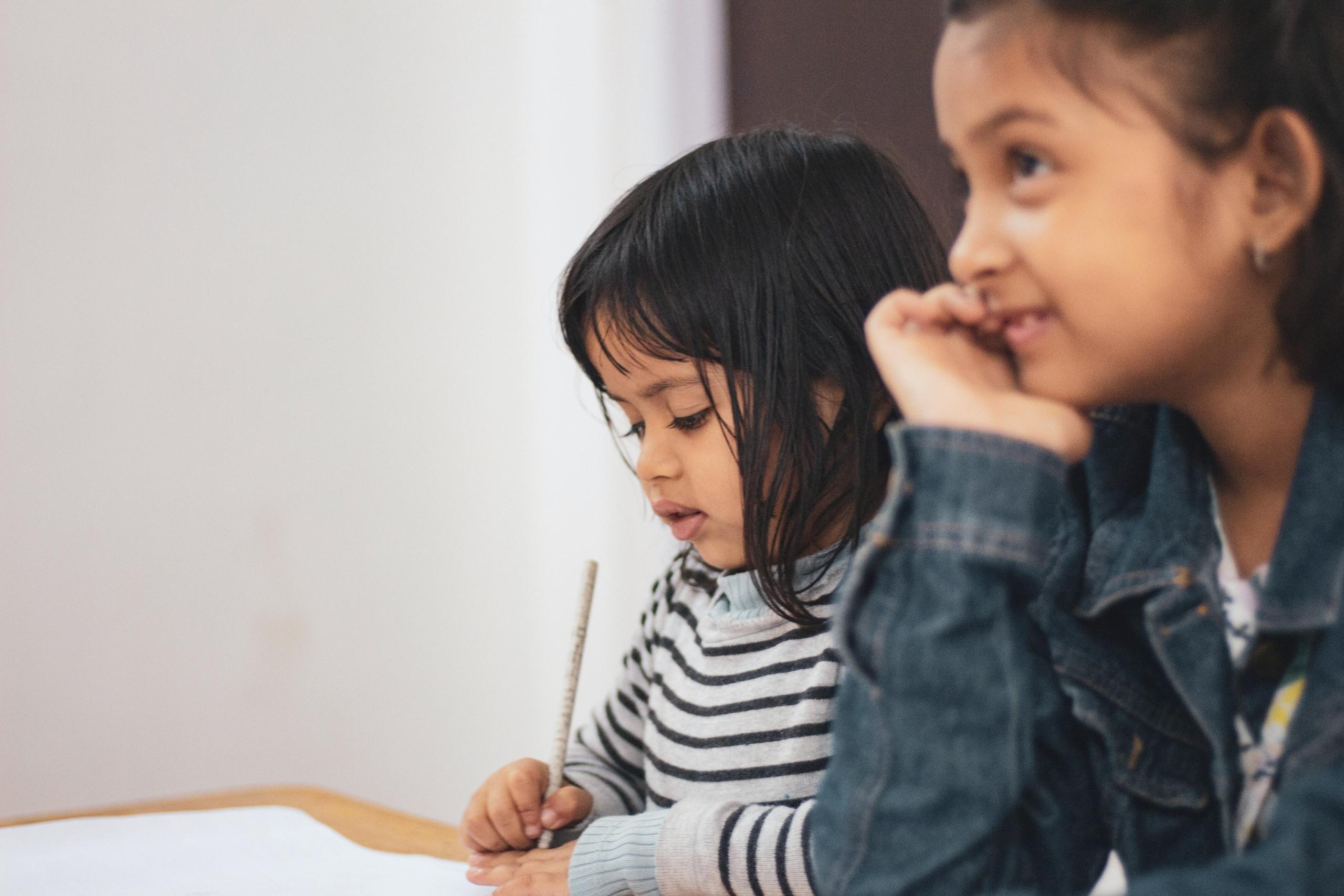 two young students sit in class