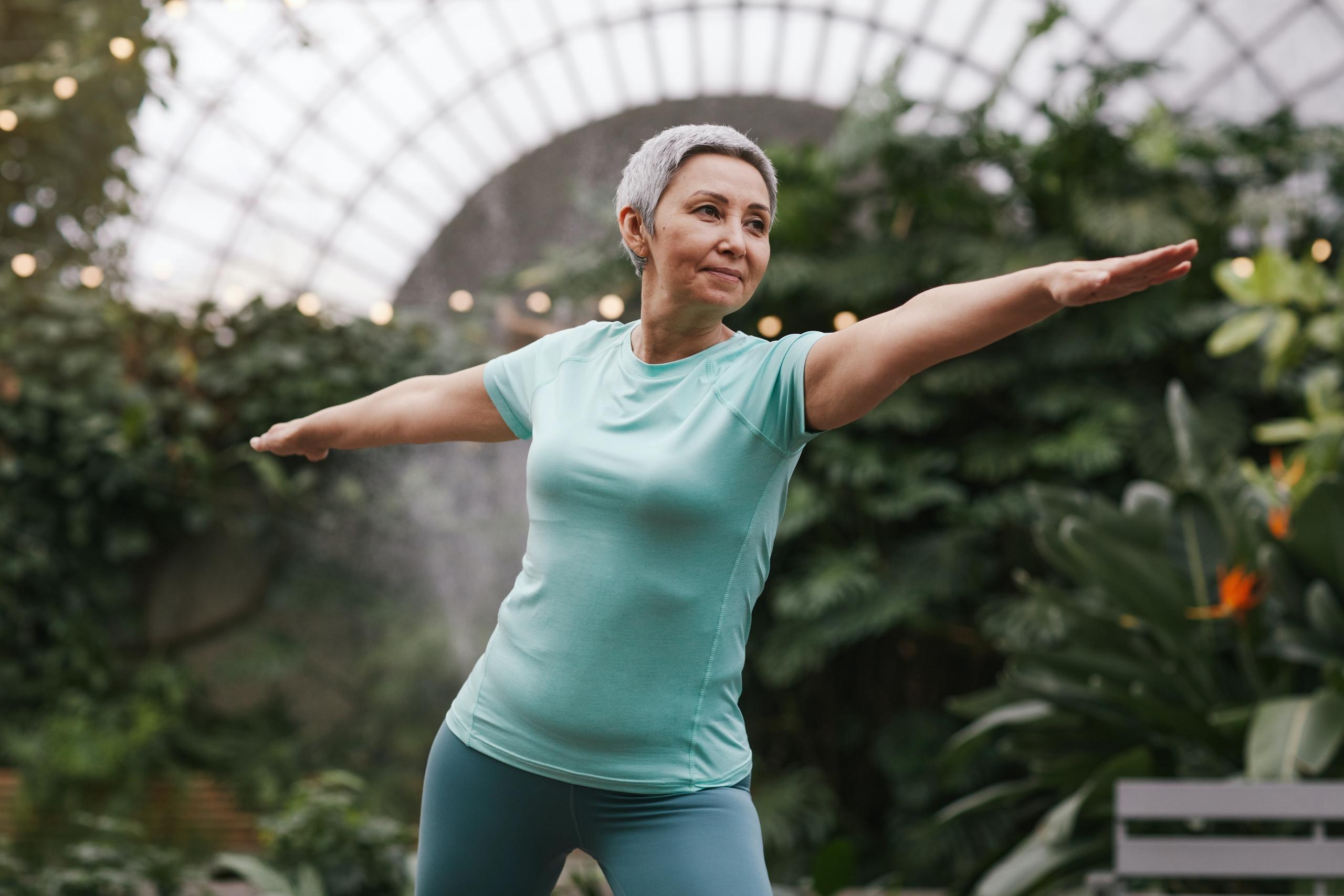 an woman in her 60s practices yoga.