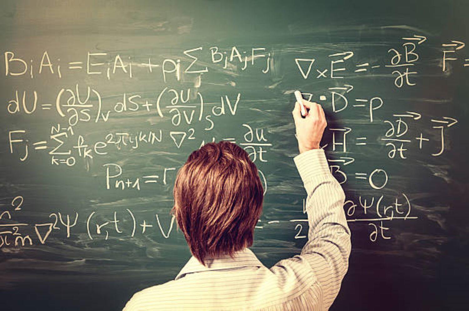 A tutor writing on a black board