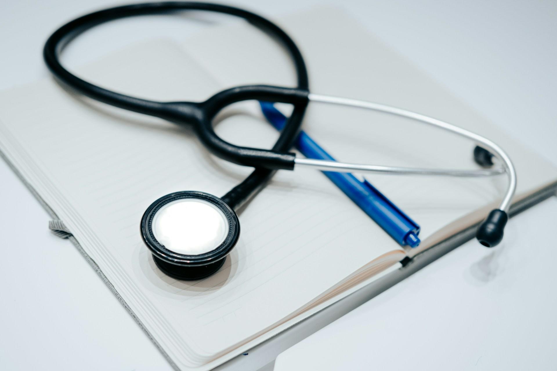 A stethoscope on top of a notebook. 
