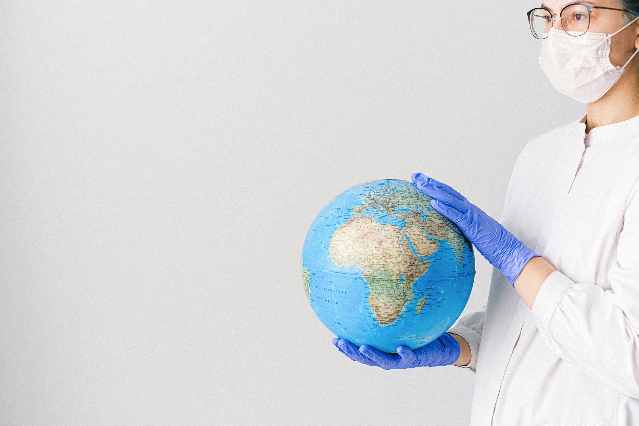a nurse stands holding a globe in her hands.