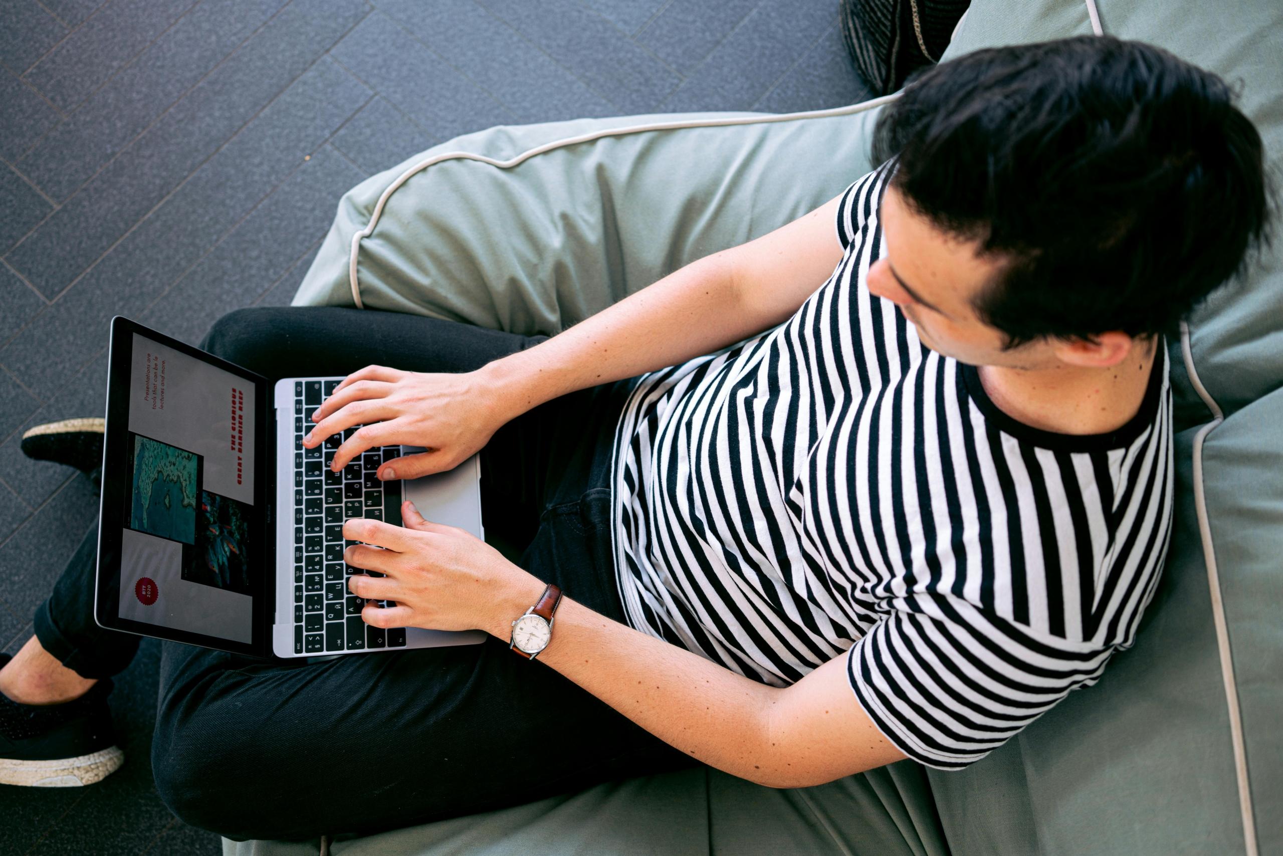 Student working on his computer in a lounge area.