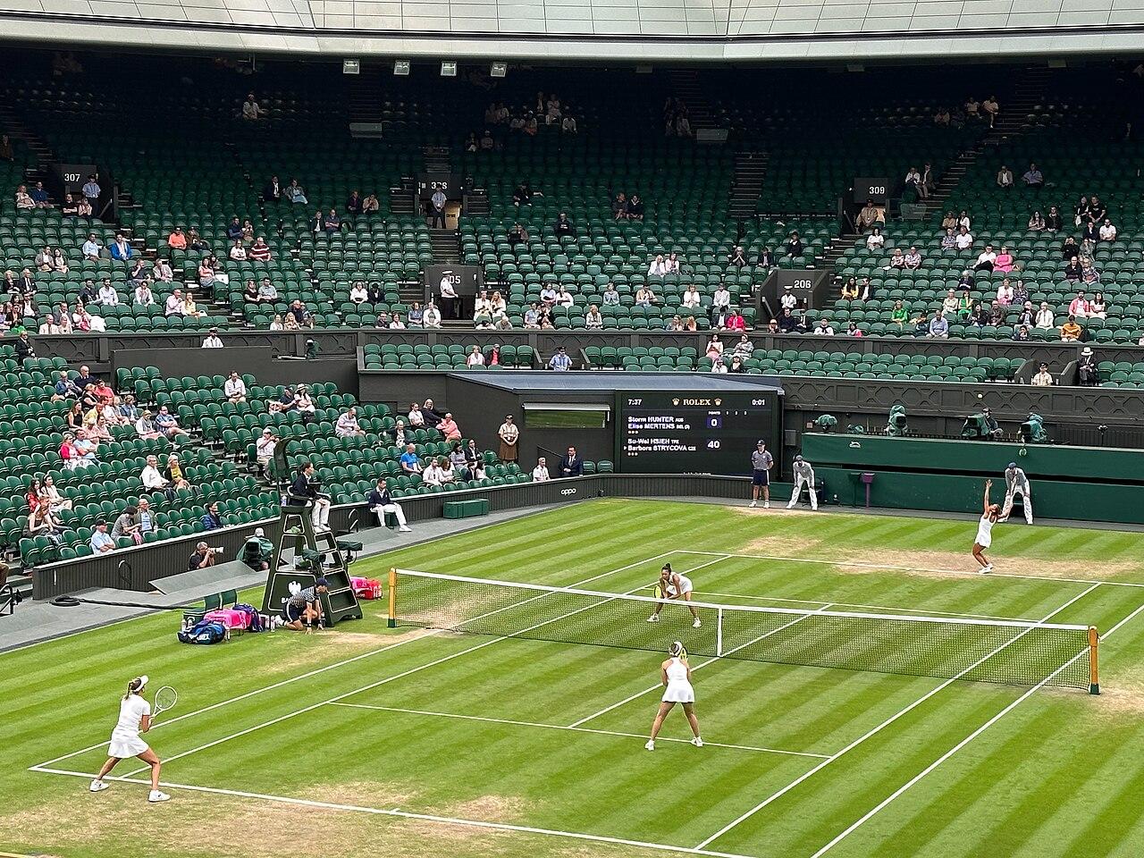 Women playing tennis in double.