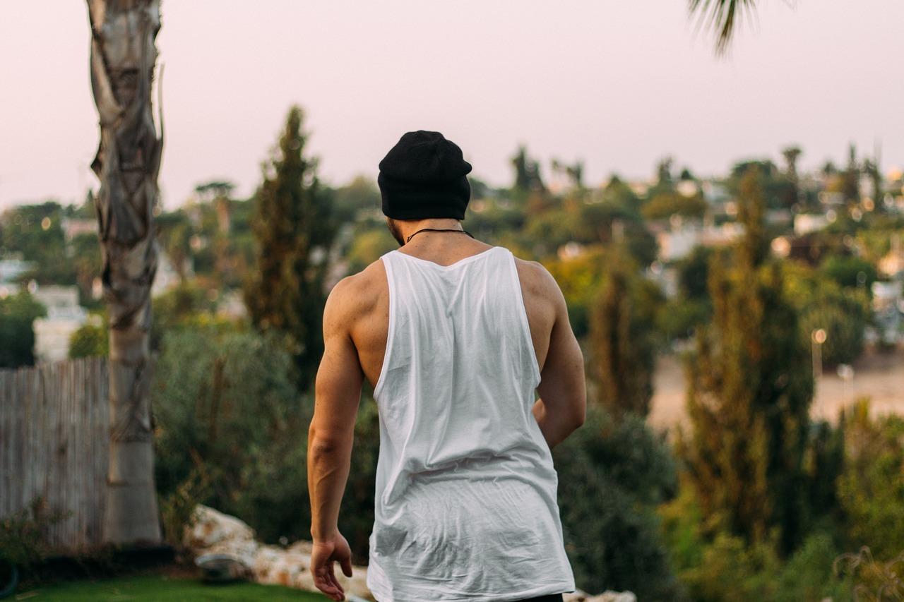 A man looking with his back to the camera thinking about his calisthenics workout routine.