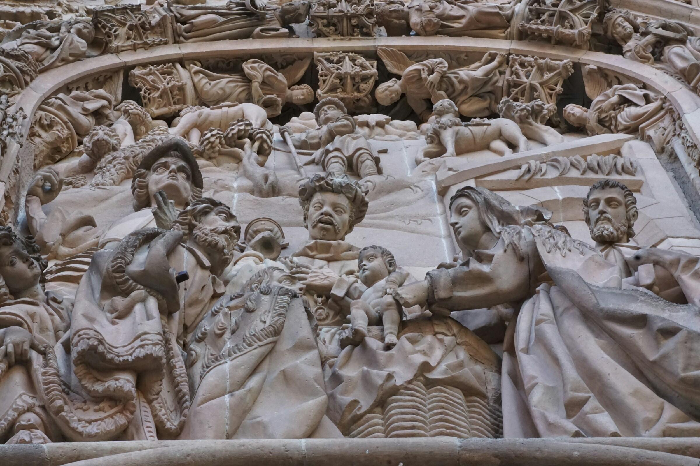 Detailed stone carvings of biblical figures, showcasing intricate drapery and expressions on a historical facade.