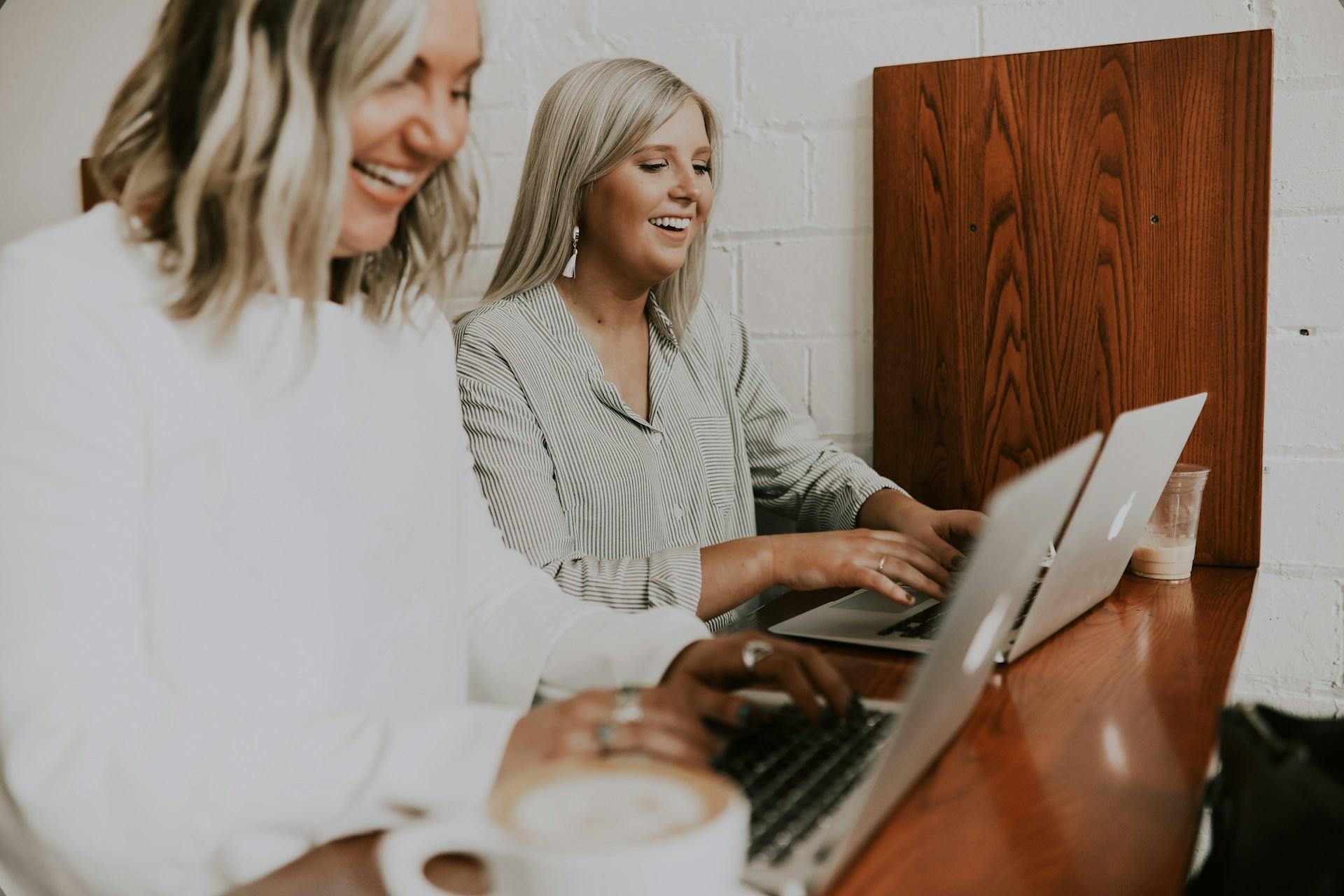 Two women working on their laptops.