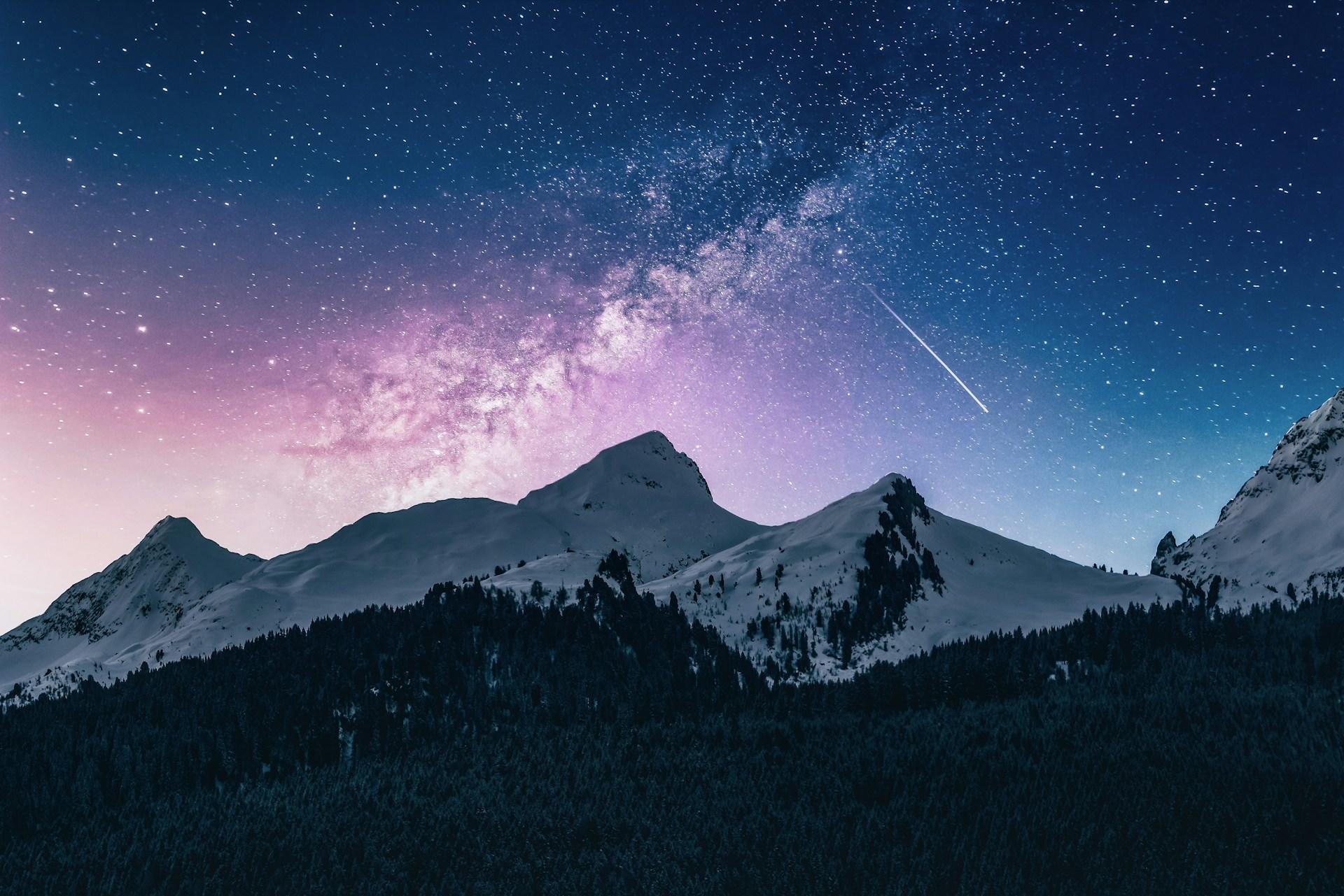 A shooting star over the winter mountains