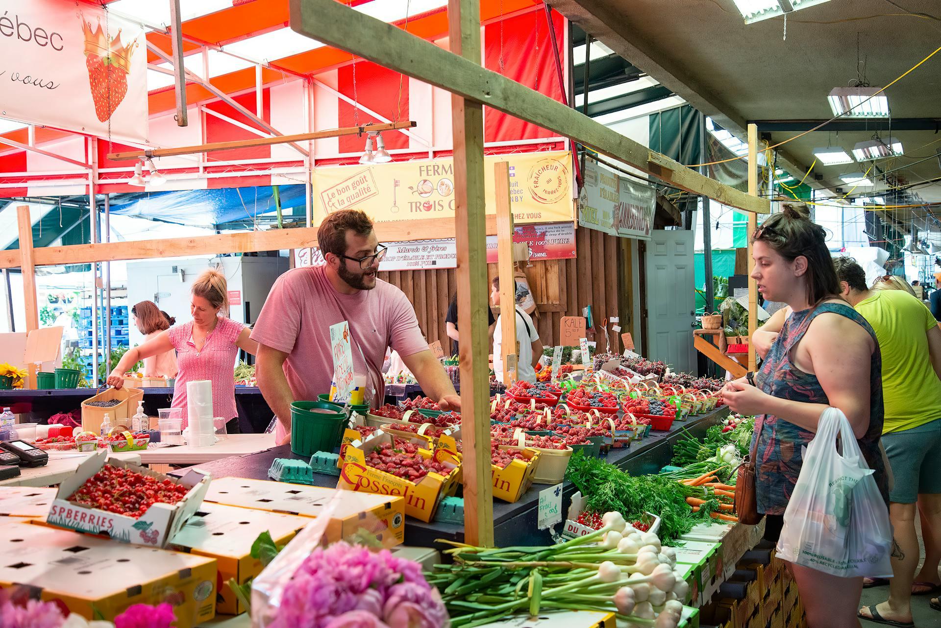 A fruit vendor chatting with a customer in a market.