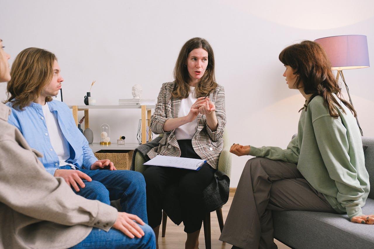 A Forensic Psychologist sitting down with 3 other people discussing a case.