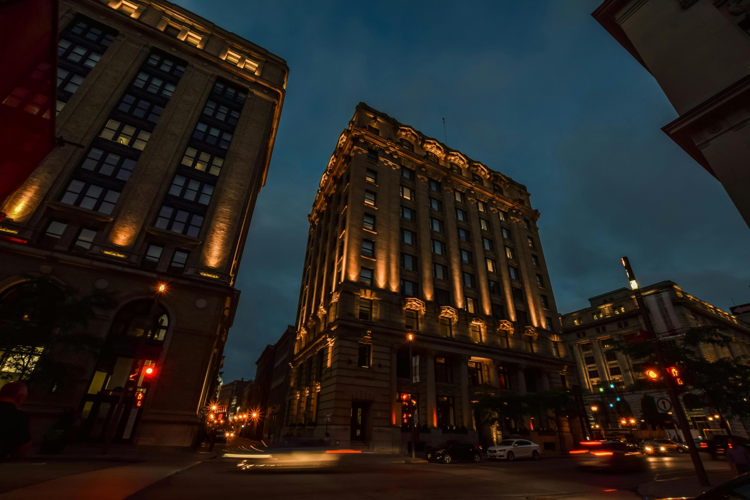 A photo of a historic building in Montreal at night. The building is lit up.