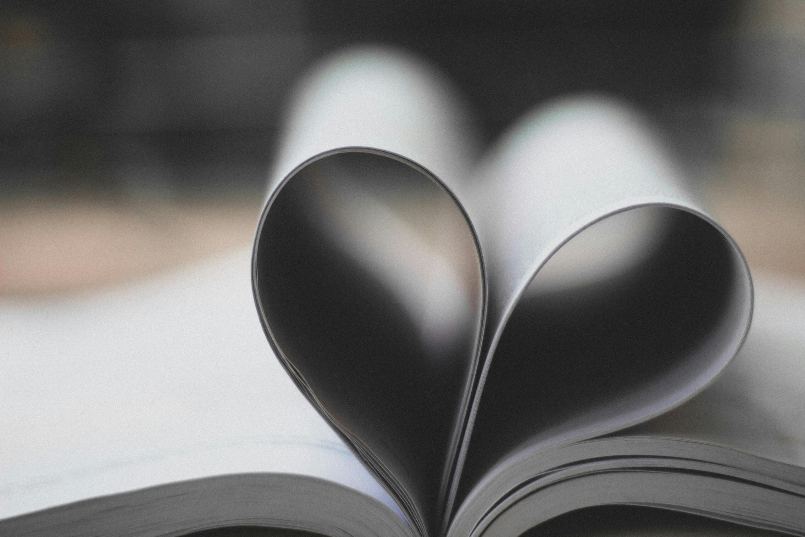 An open book with its pages gently curved to form the shape of a heart, symbolizing a love for poetry.