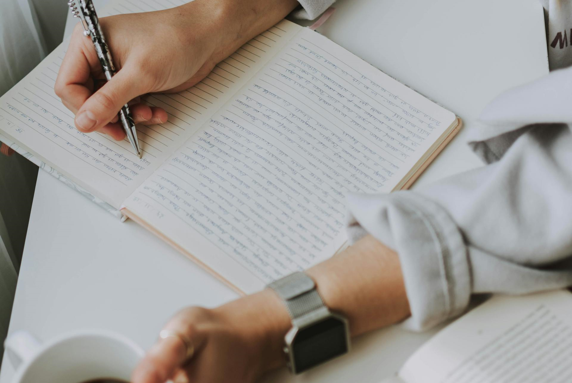 Someone writing on a notebook