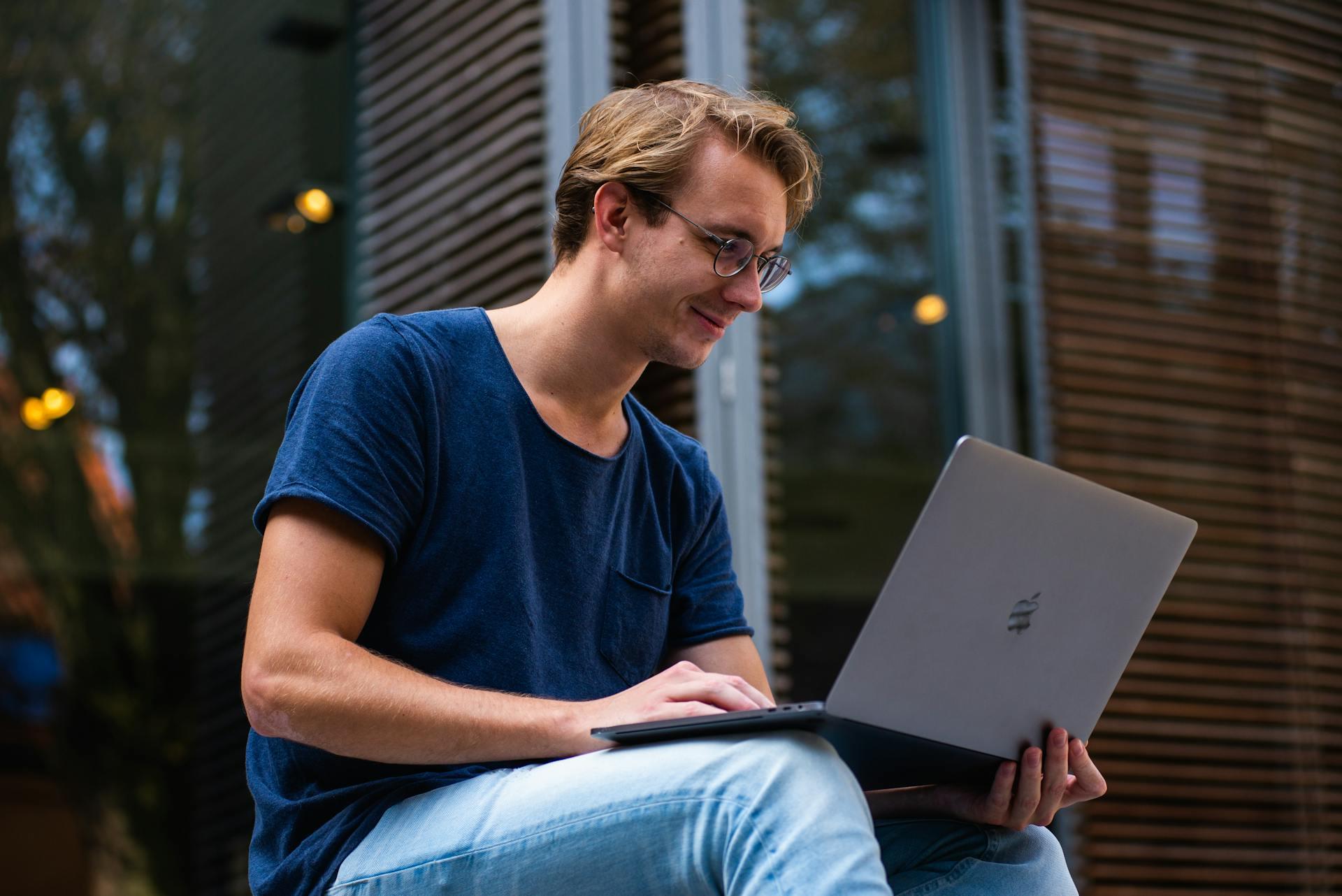 Man smiling and using his computer.