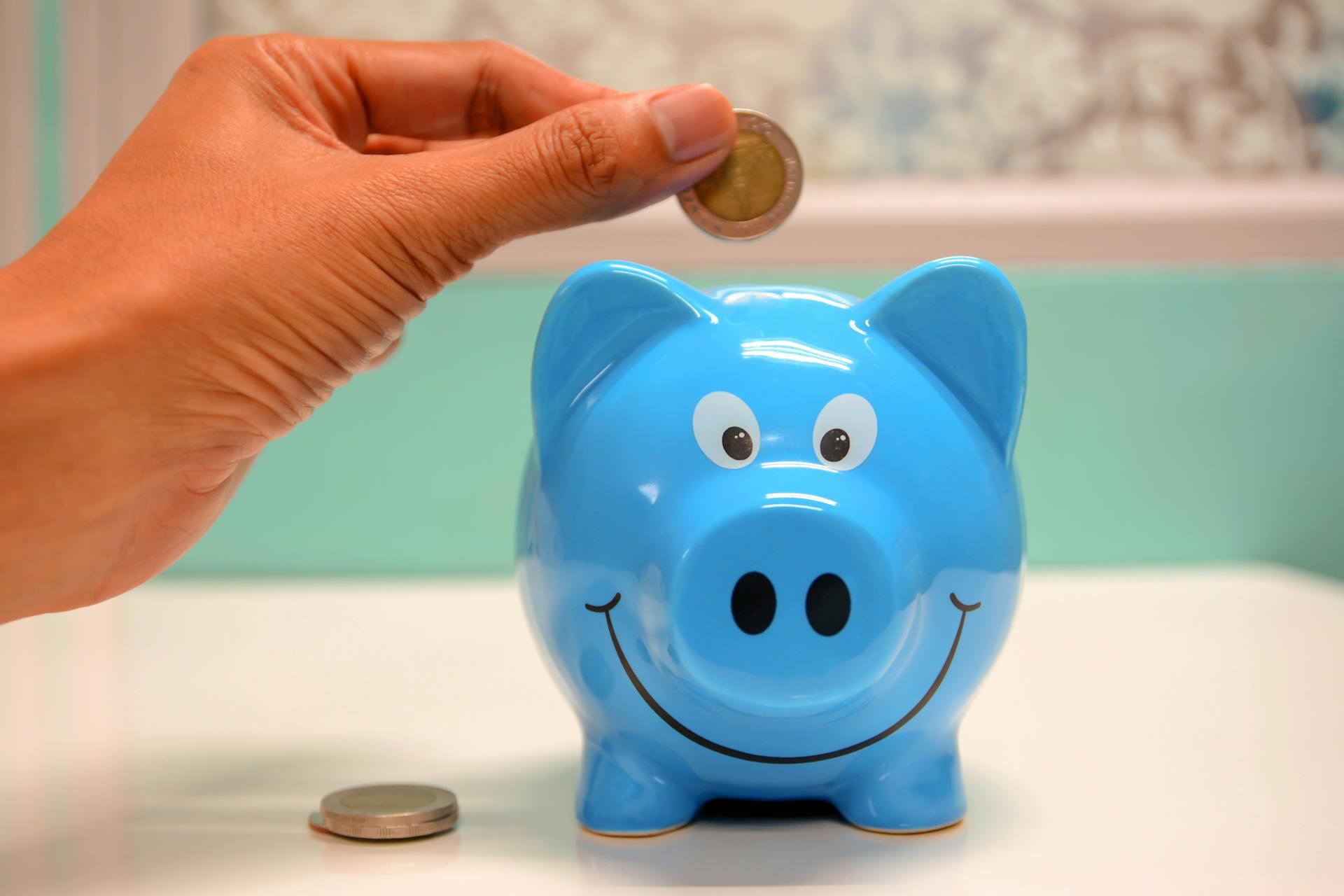 A person inserting a coin into a money box.