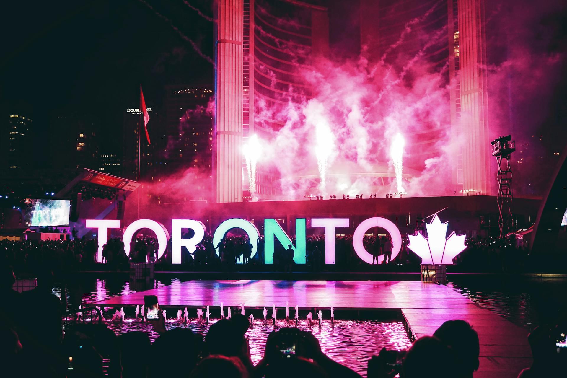 People partying in front of Toronto's standing sign