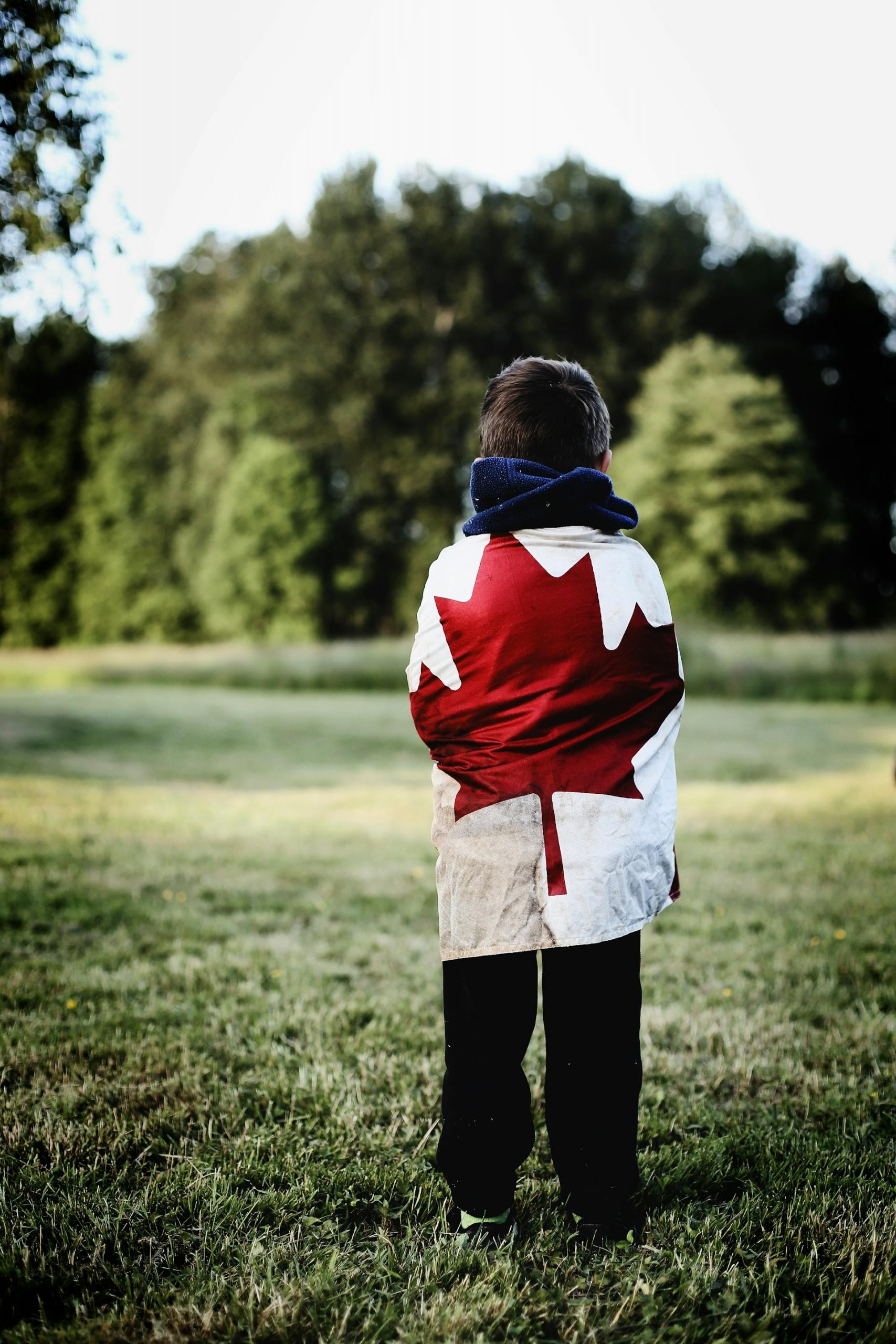 a child wearing a shirt showing the maple leaf, an iconic symbol of Canada.