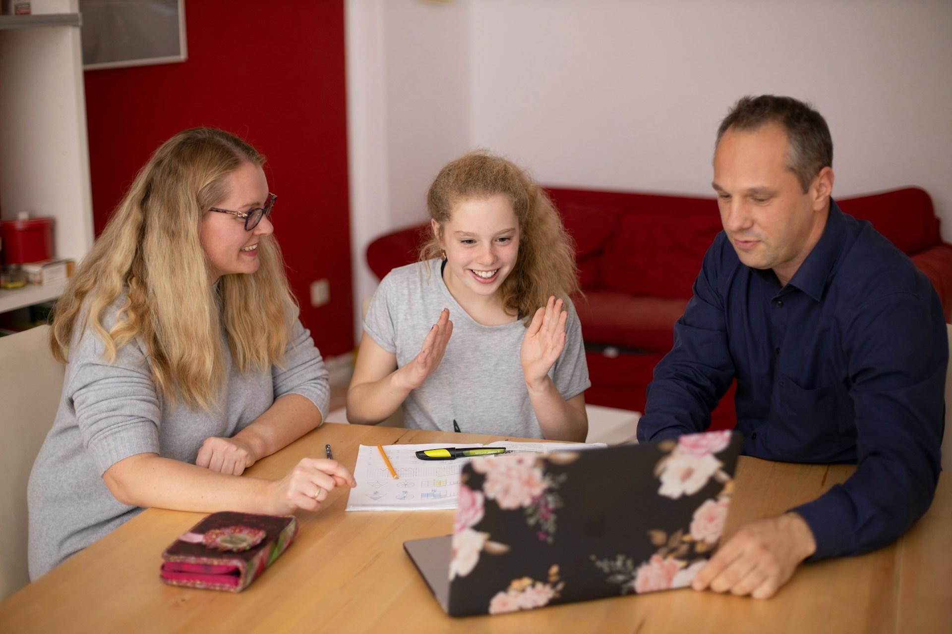 Parents and daughter discussing and watching something together