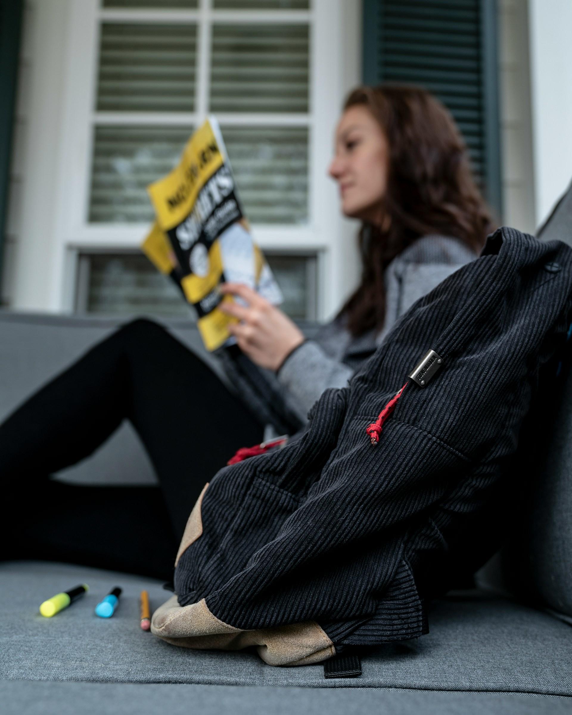 A female student reading a book by herself.