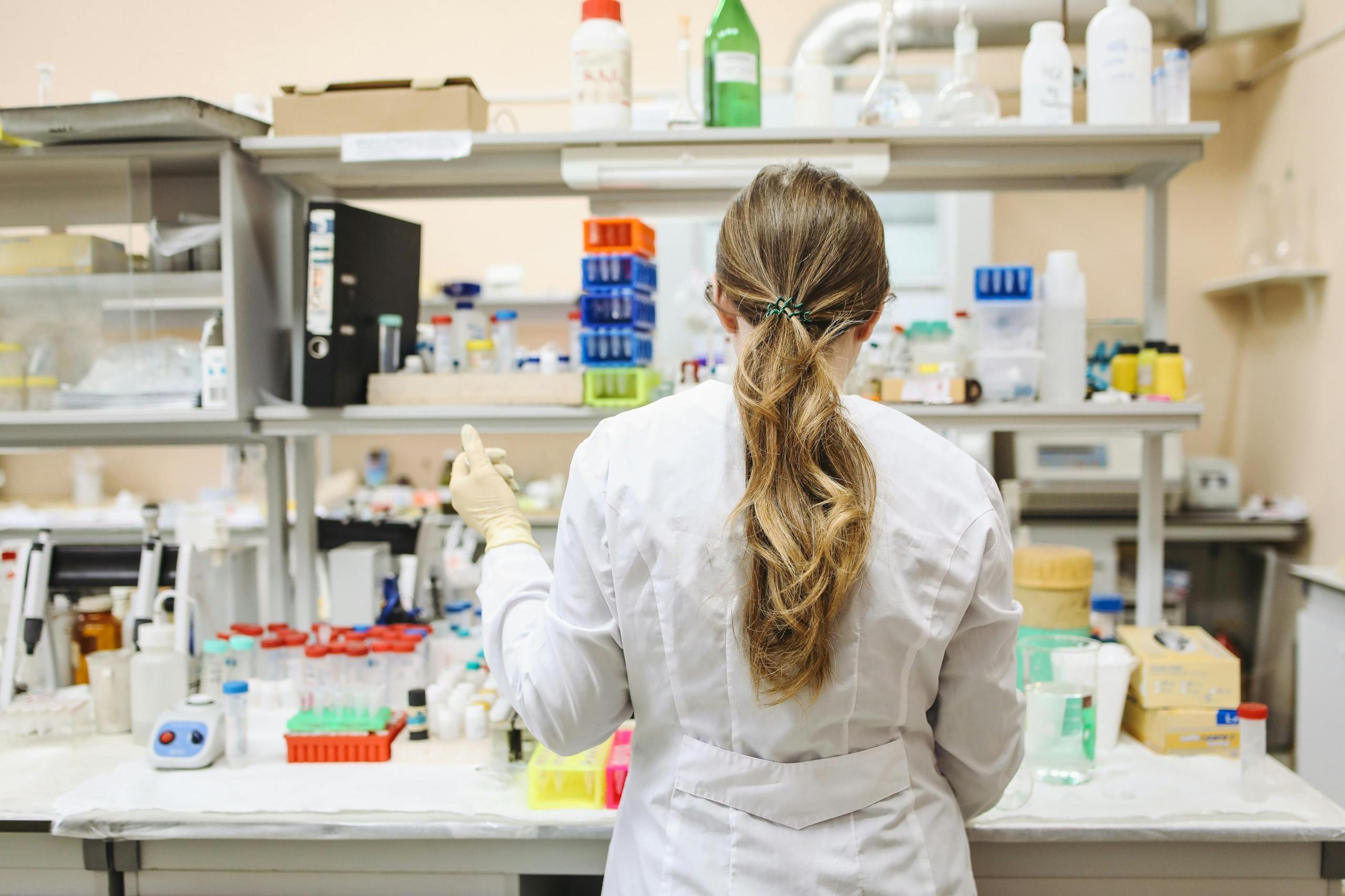 A female chemical engineer working in a laboratory, surrounded by scientific equipment, analyzing chemical processes for product development.