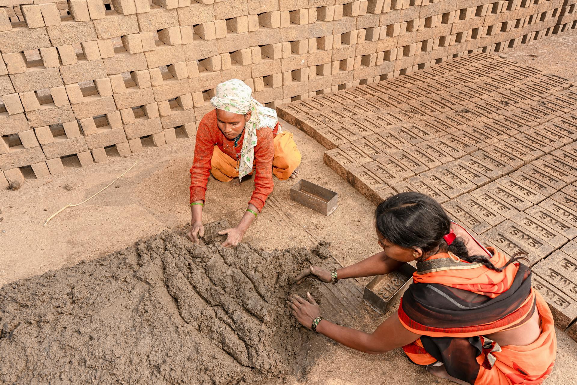 Women creating bricks with earth in an artisanal way.
