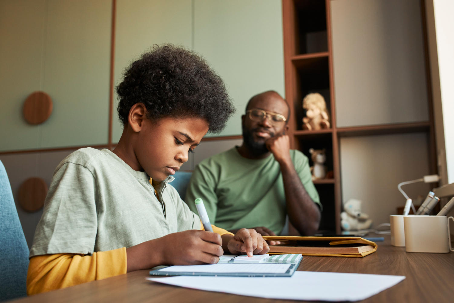 A father watching his son doing homework