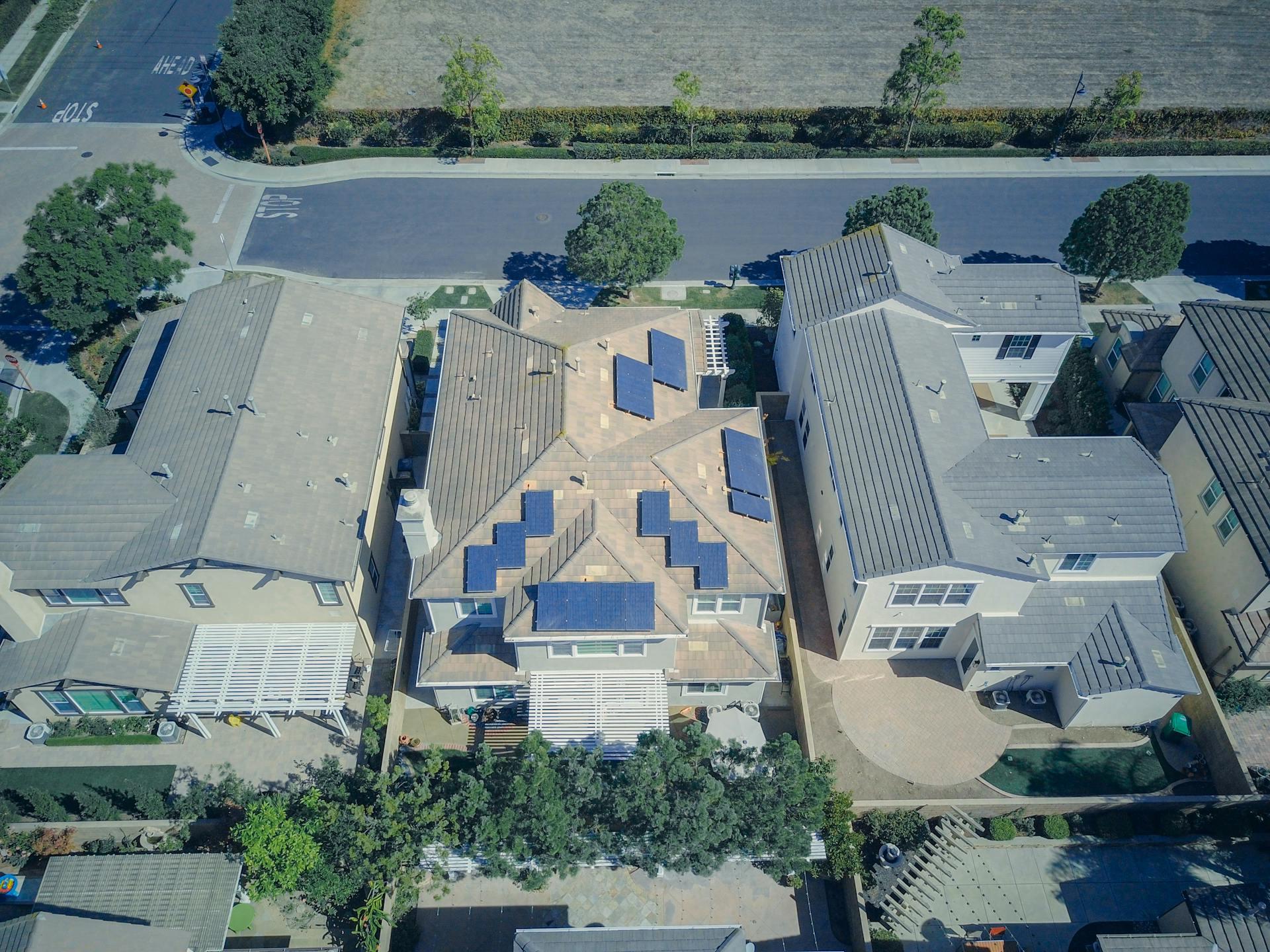Photograph showing a set of houses with solar panels on the roof.