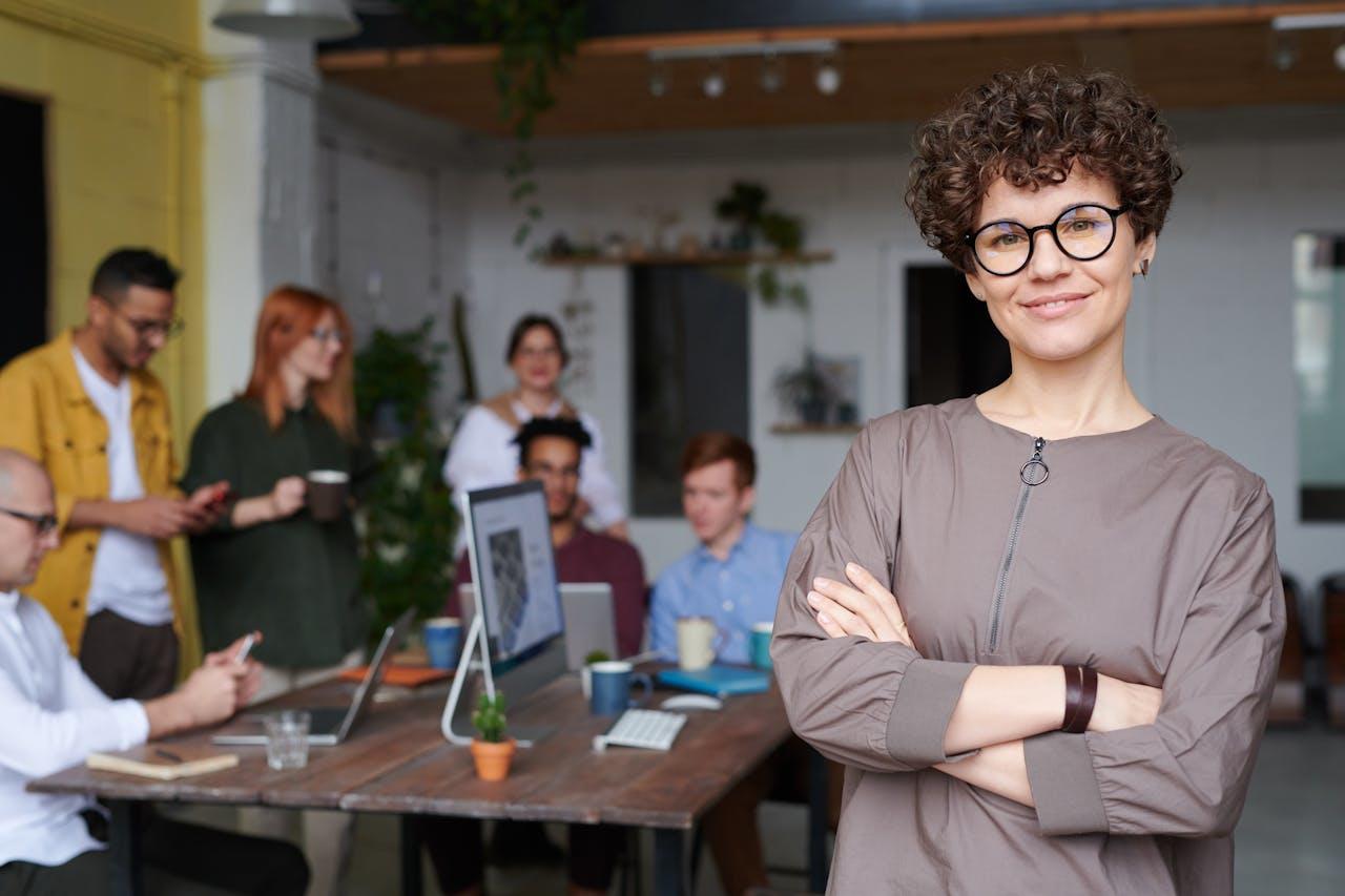 A women leader standing in front of her co-workers at a table.
