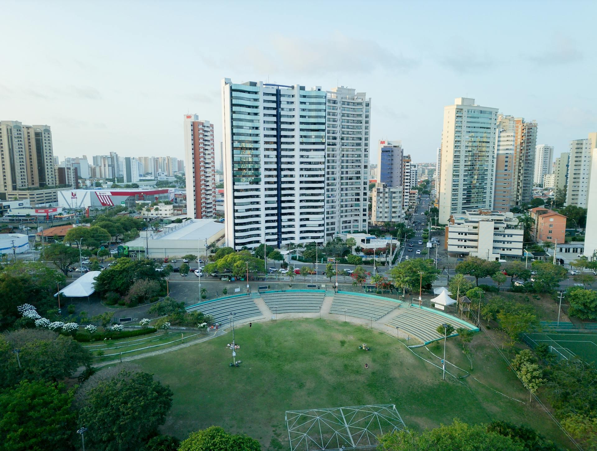Photograph showing buildings in the background and green spaces in front of them.