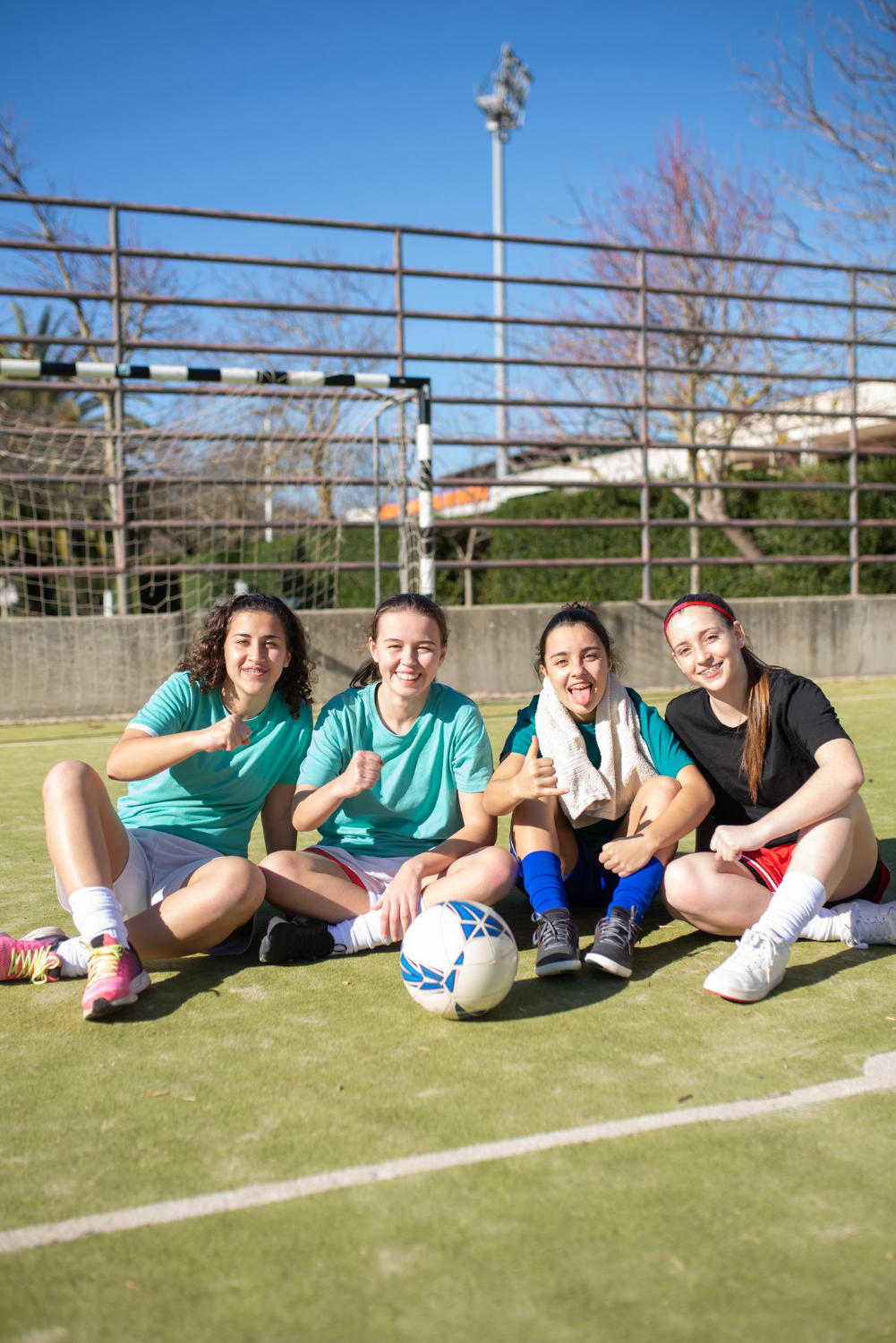 female studednts sitting at a football field