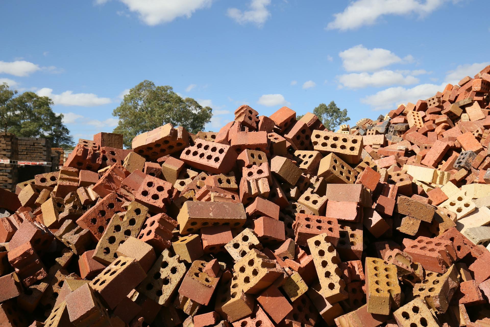 Heap of red broken bricks in construction area.