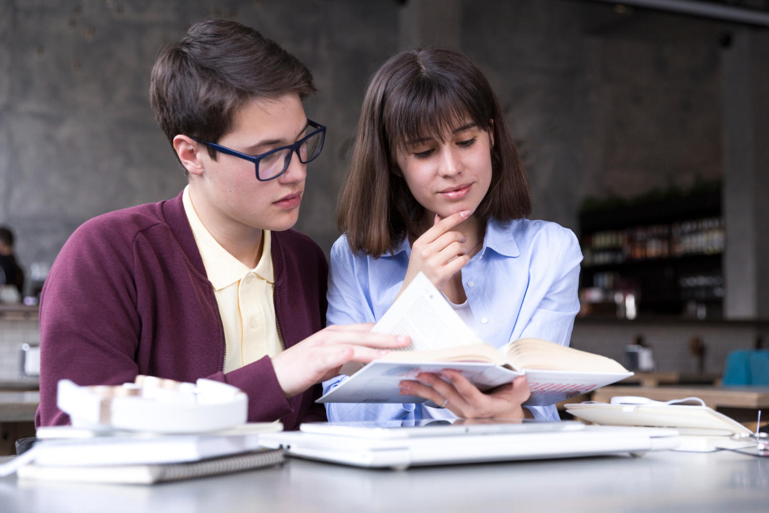 two students looking at a book together