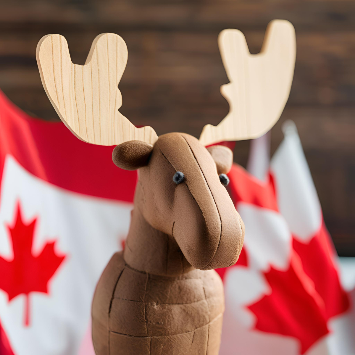 A wooden moose figure with Canadian flags in the background, symbolizing Canada.