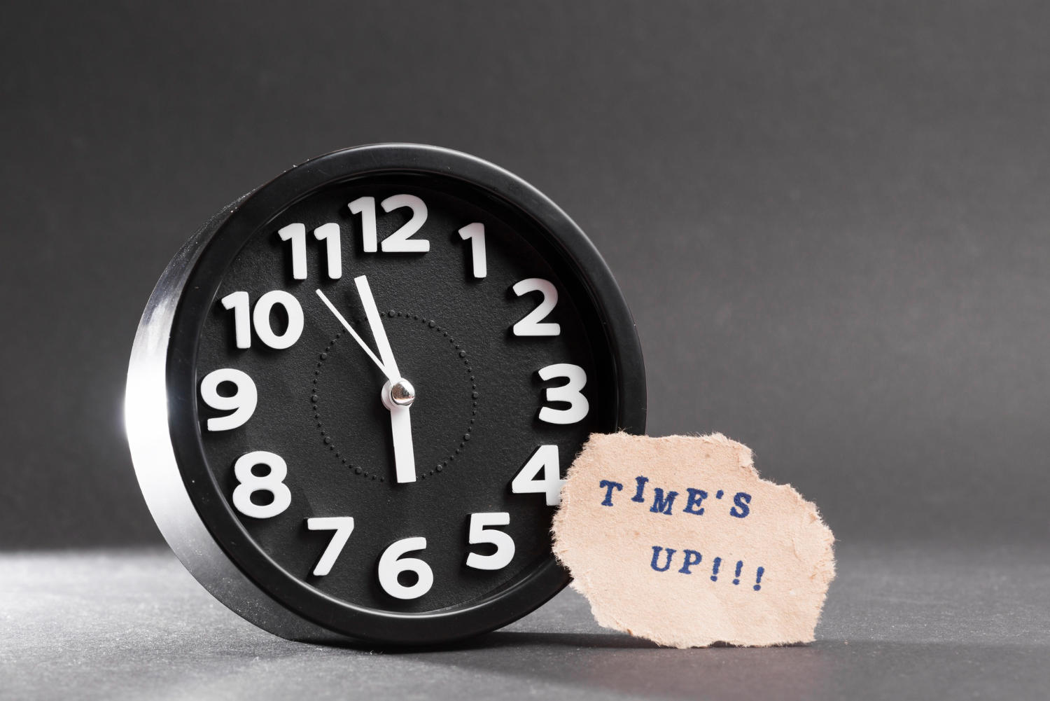 a clock with a paper saying time's up