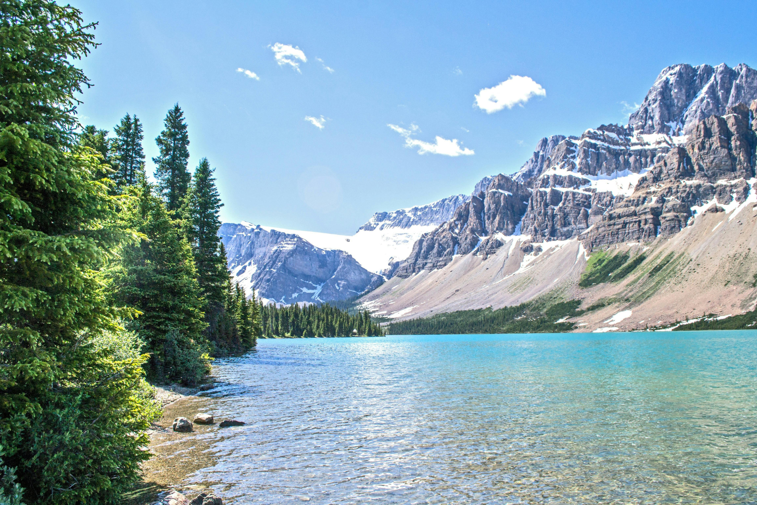 Crystal-clear turquoise waters of a serene lake surrounded by towering mountains in Banff National Park.
