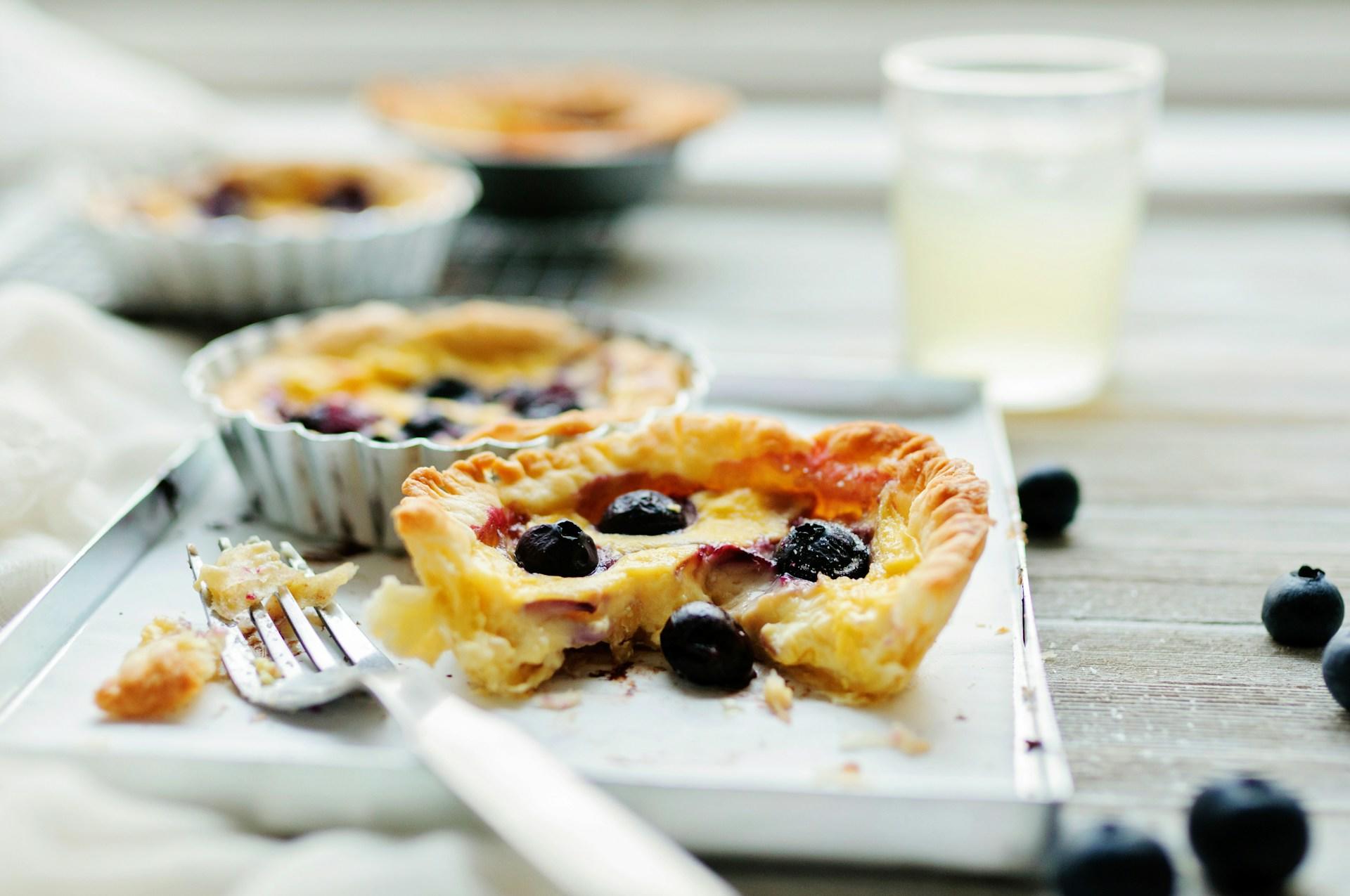 The picture shows baked butter tarts decorated with fruit and ready to eat.