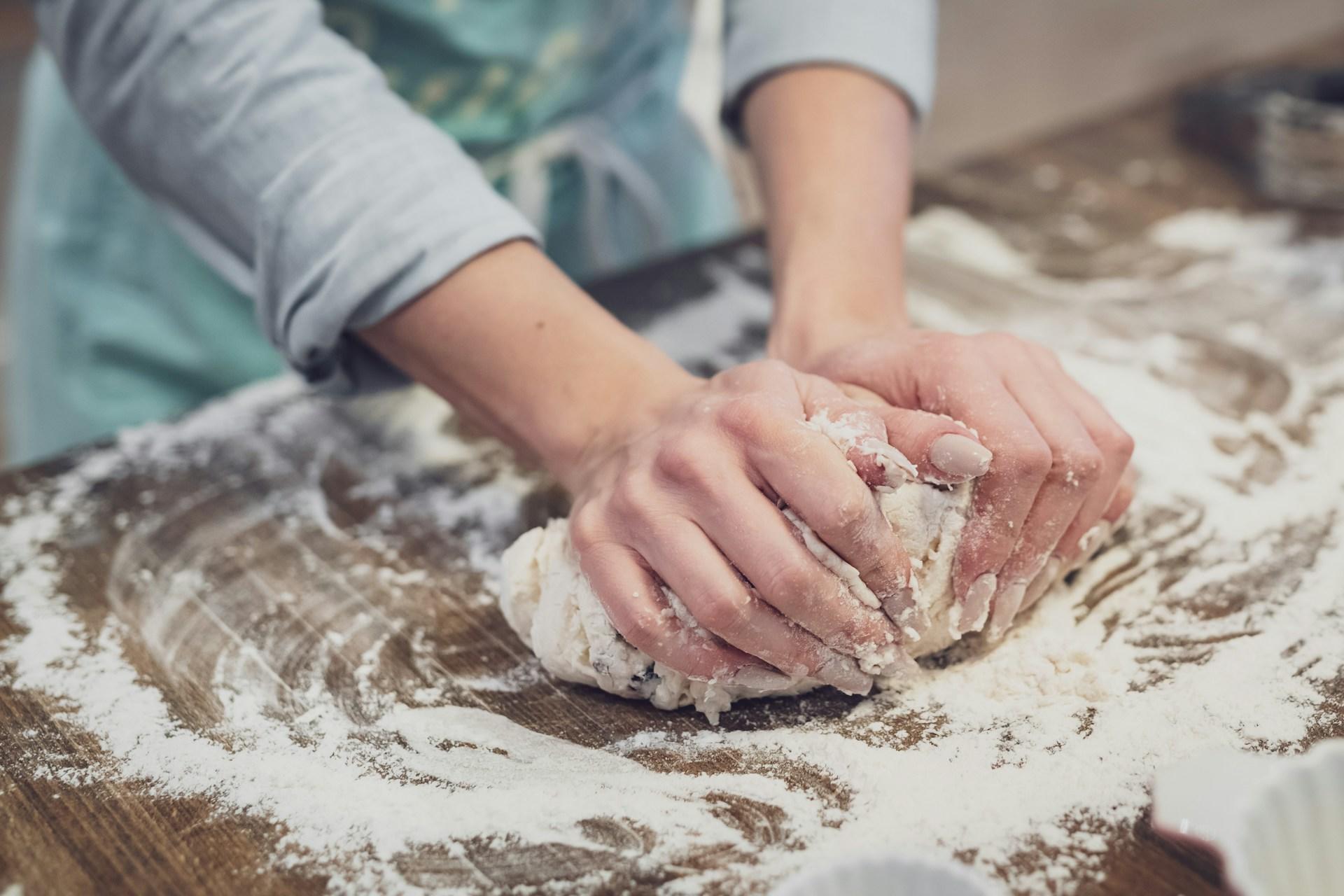 The photograph shows a woman kneading dough to make butter tarts and finds the entire surface full of flour.