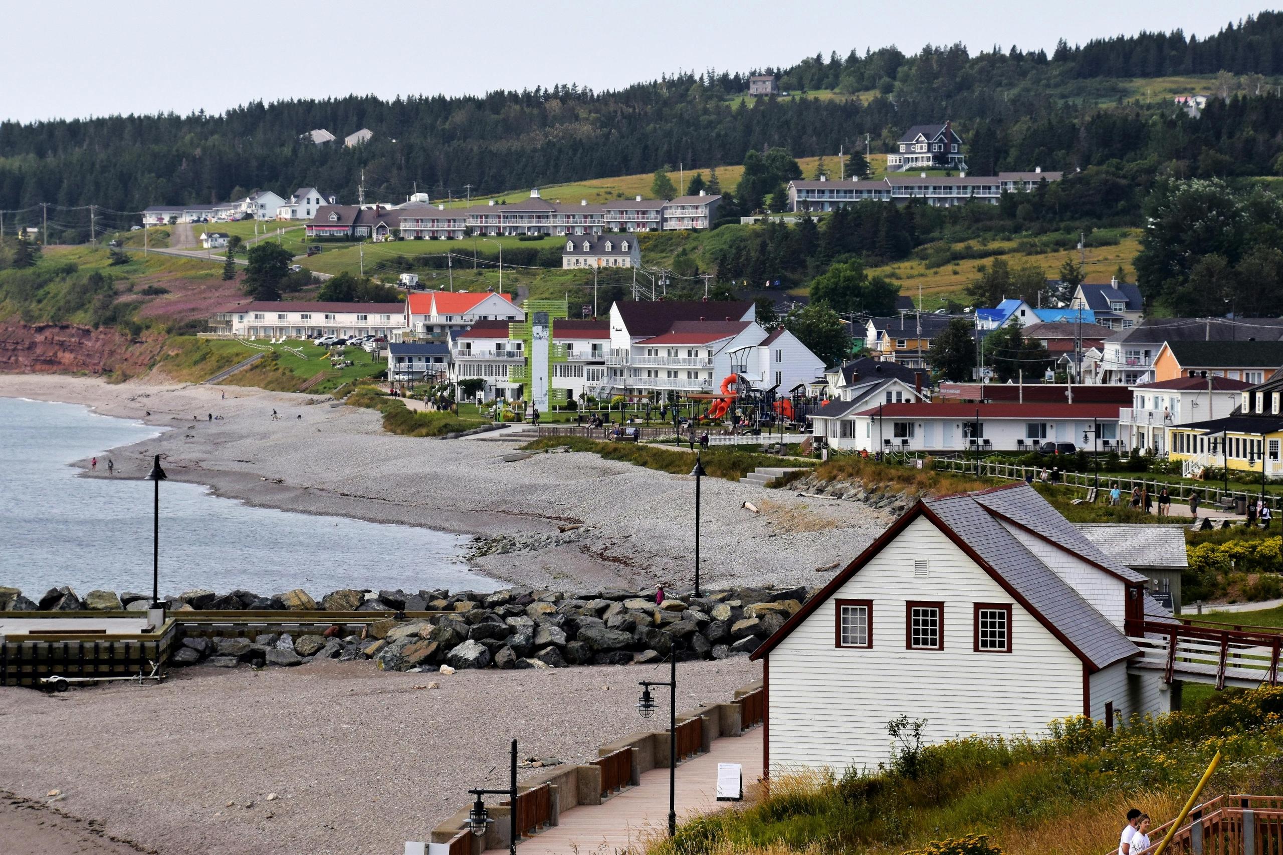 a coastal town with a white house near the beach.