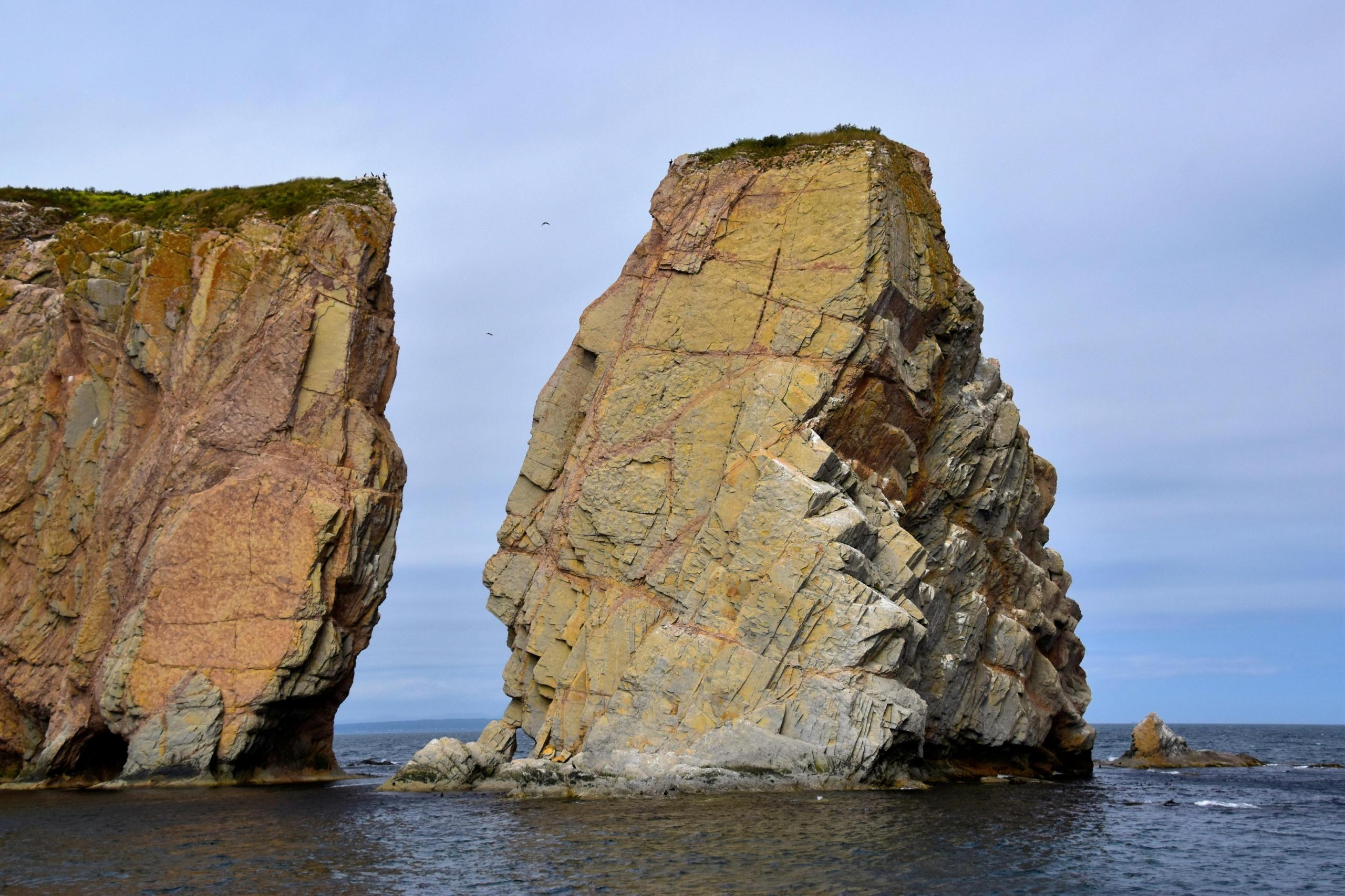 two giant rock formations rise from the water.