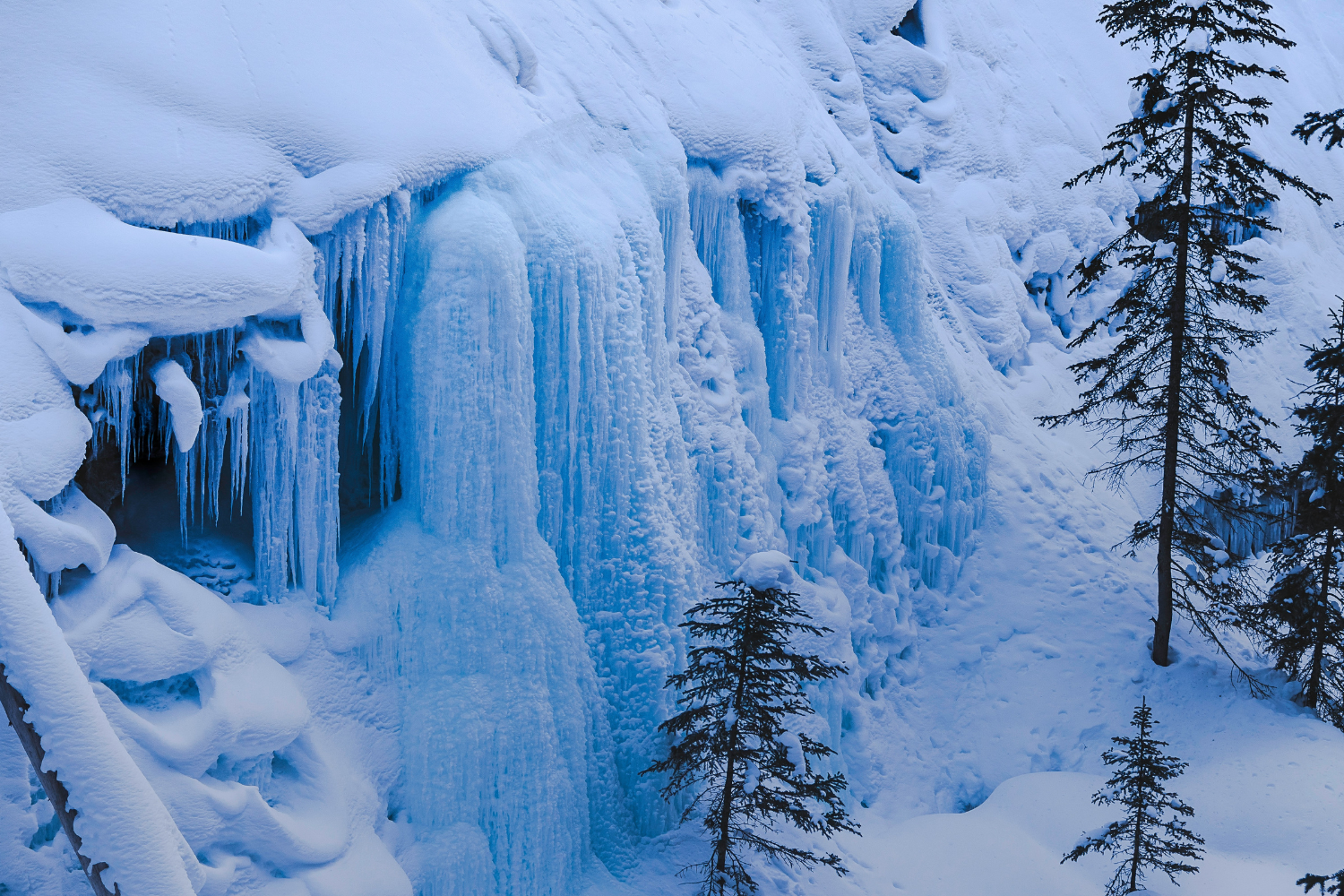 Frozen waterfalls and ice-covered cliffs at Johnston Canyon in Banff National Park during winter.