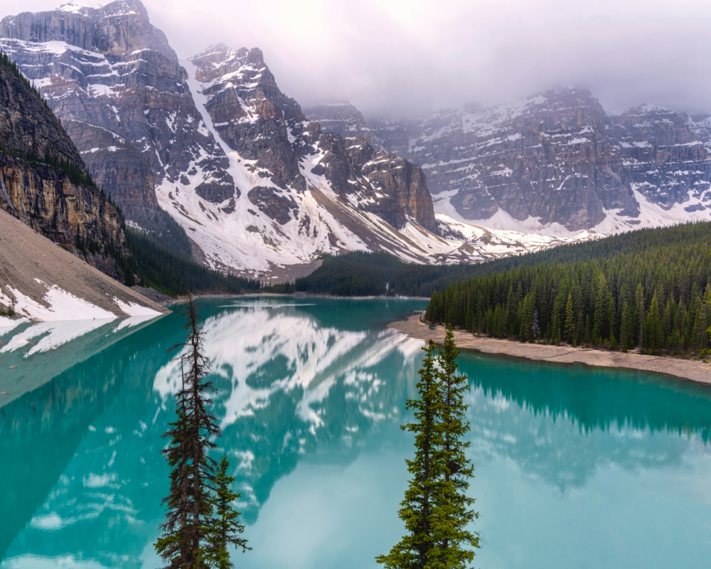 Turquoise waters of Moraine Lake surrounded by snow-capped peaks in Banff National Park.