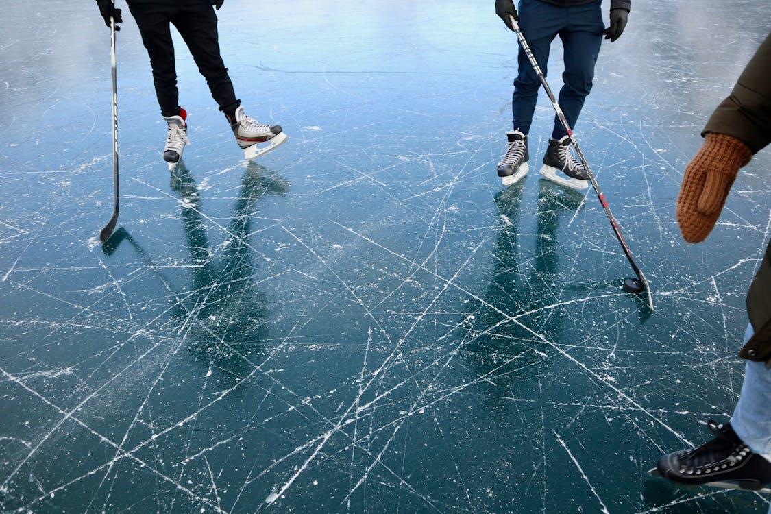 The photograph shows 3 men playing ice hockey.