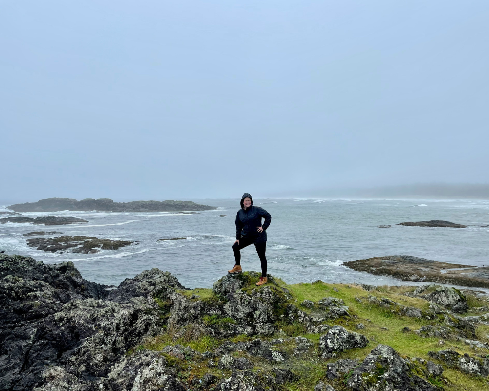A visitor exploring the rugged coastline of Pacific Rim National Park Reserve on a misty day.