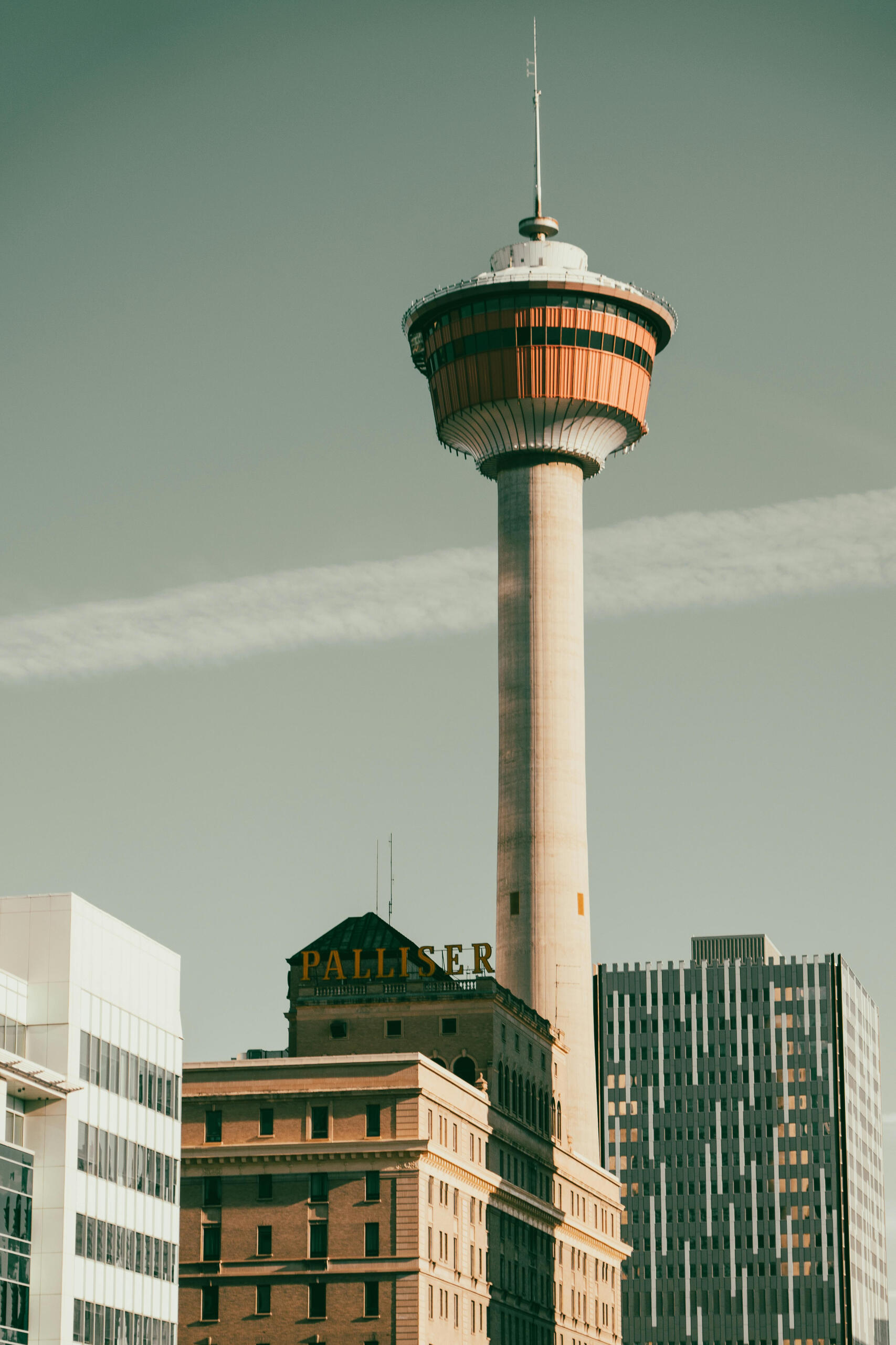 Downtown Calgary's skyline - A tall observation tower rises above surrounding buildings against a clear sky with a contrail.